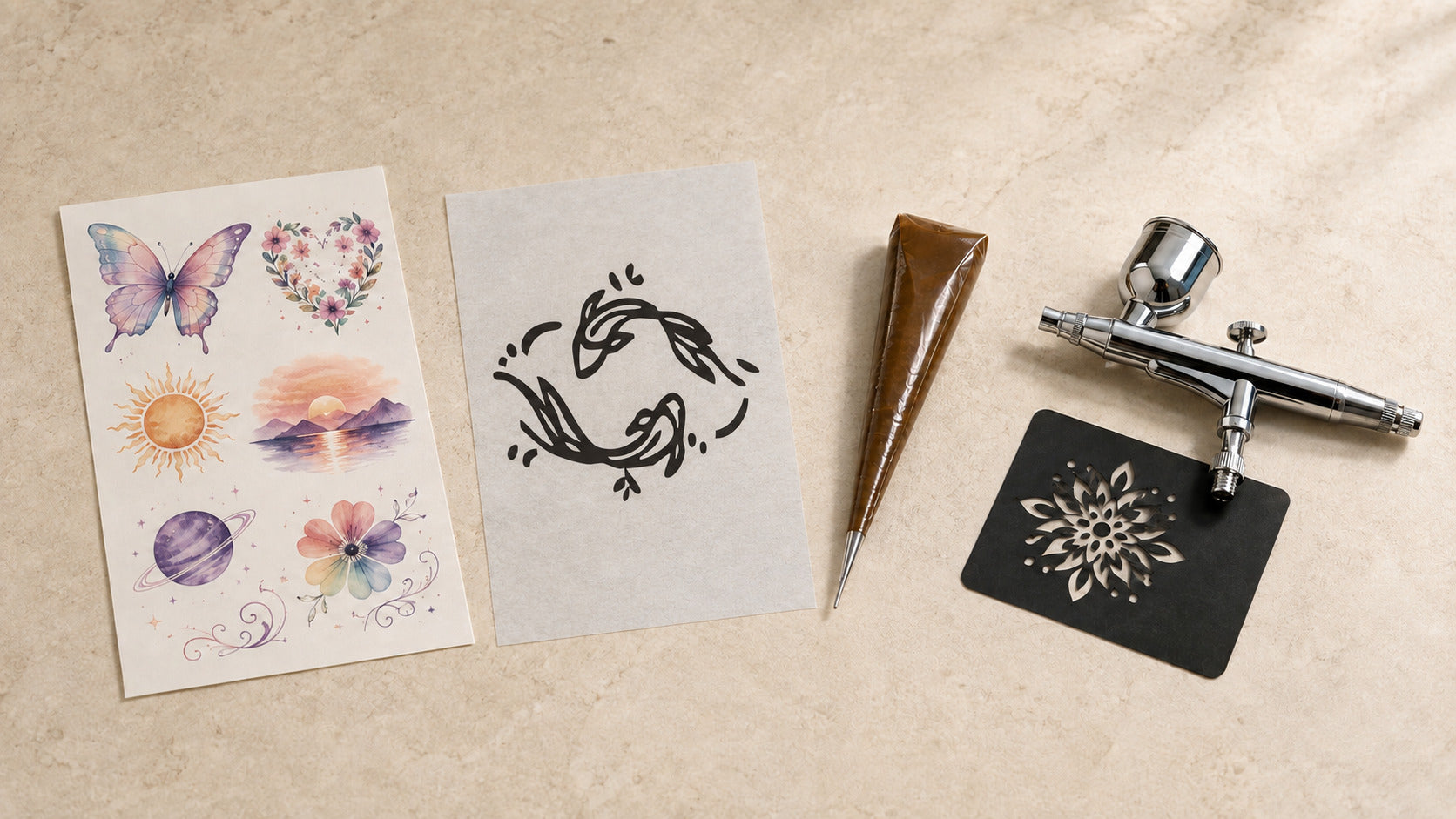Semi permanent tattoos, water-transfer designs, airbrush tools, and a stencil displayed together on a warm neutral surface.