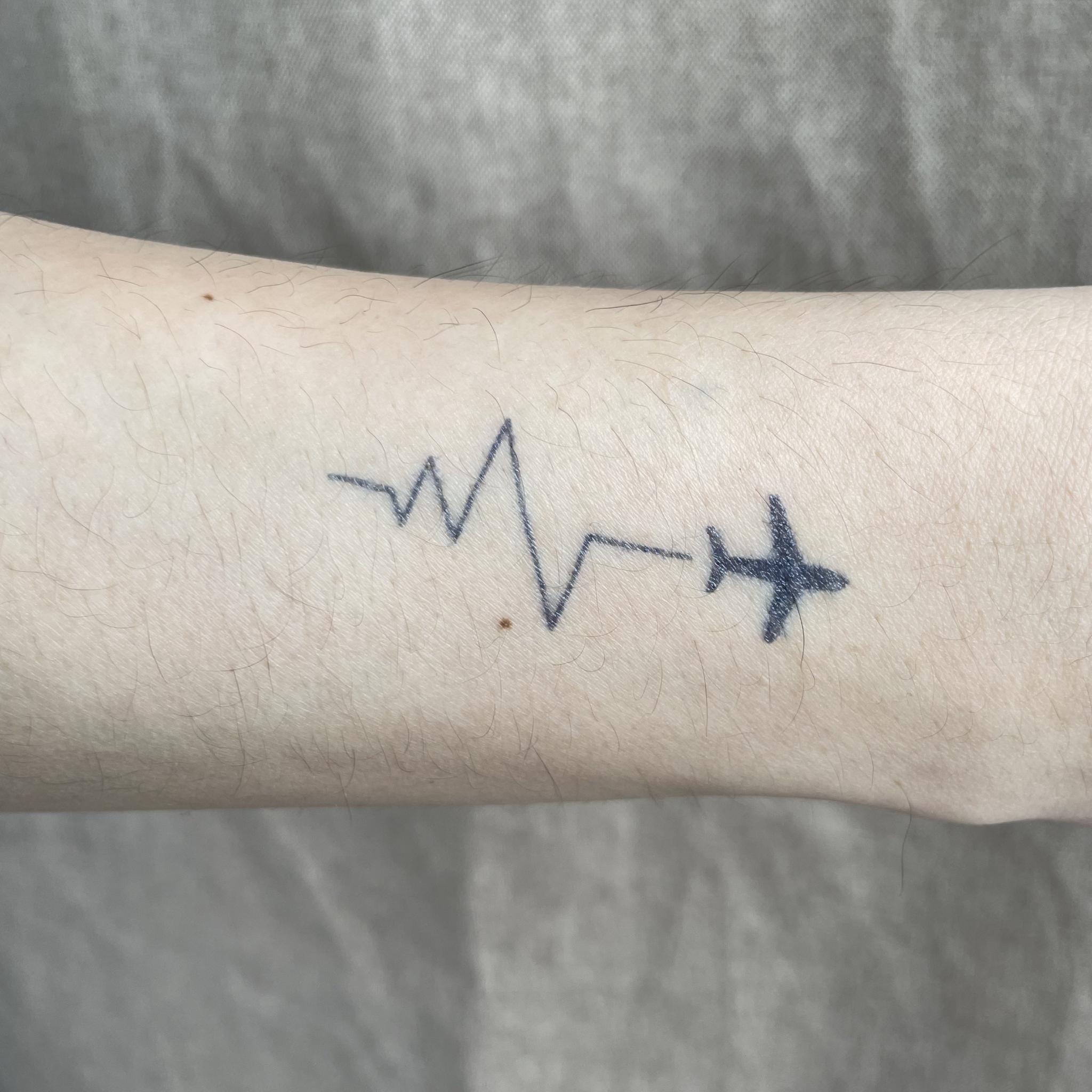 Airplane heartbeat semi-permanent tattoo on forearm