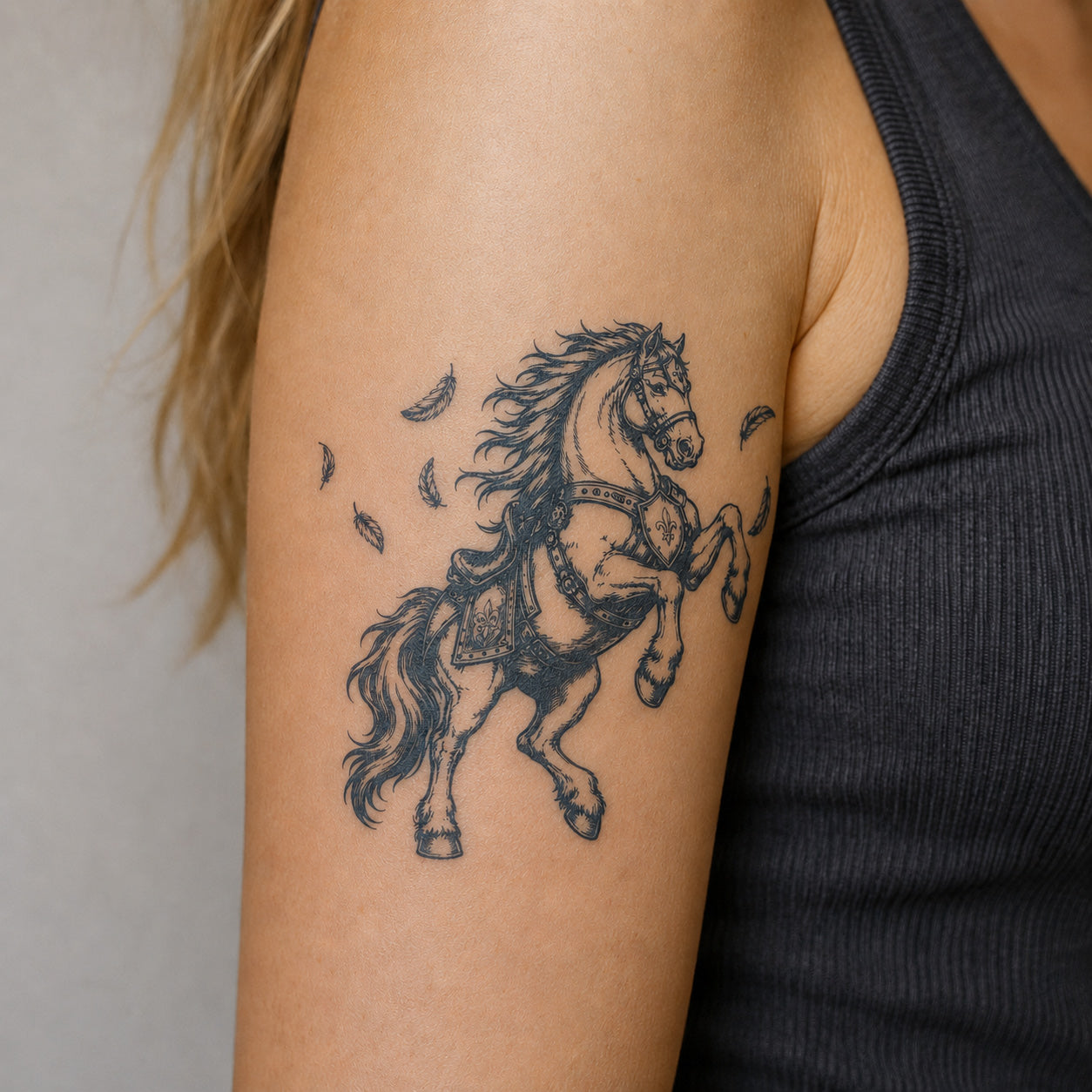 Detailed armored horse warrior design on the upper arm featuring a vintage style temporary tattoo with flowing mane, feathers, and fine artistic line details.