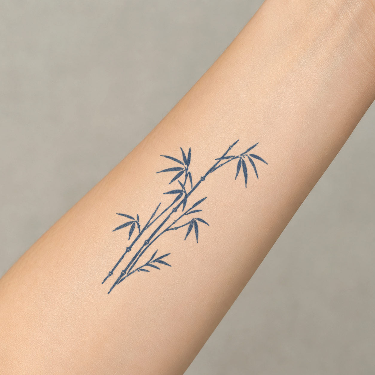 Temporary forearm tattoos featuring slender bamboo stalks with pointed leaves and small branch joints.
