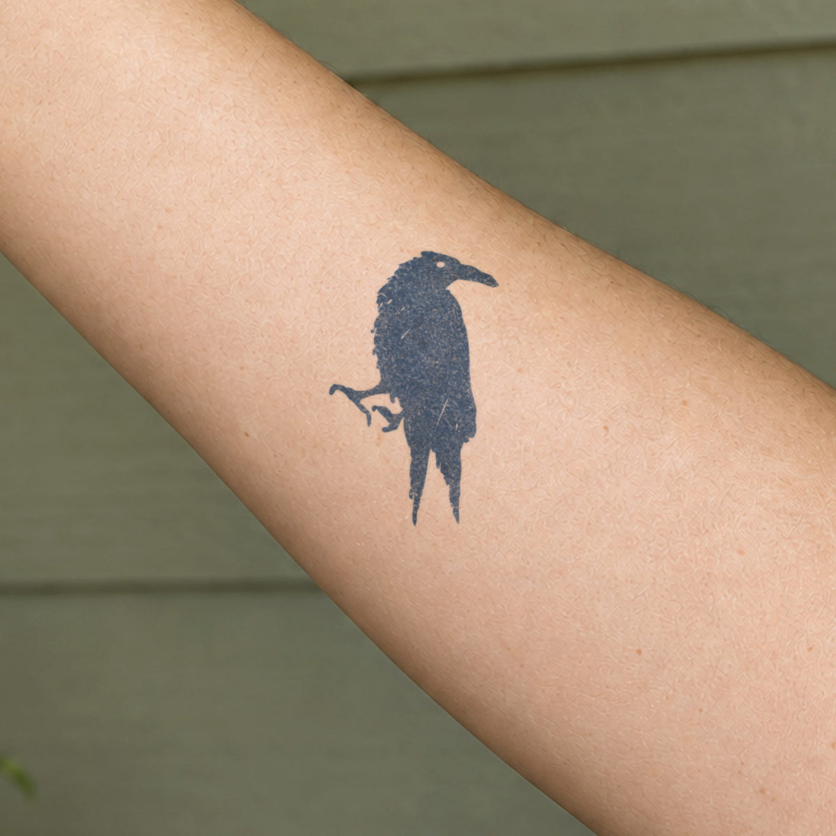 Nature temporary tattoos featuring a dark raven silhouette in blue-black ink on the forearm.