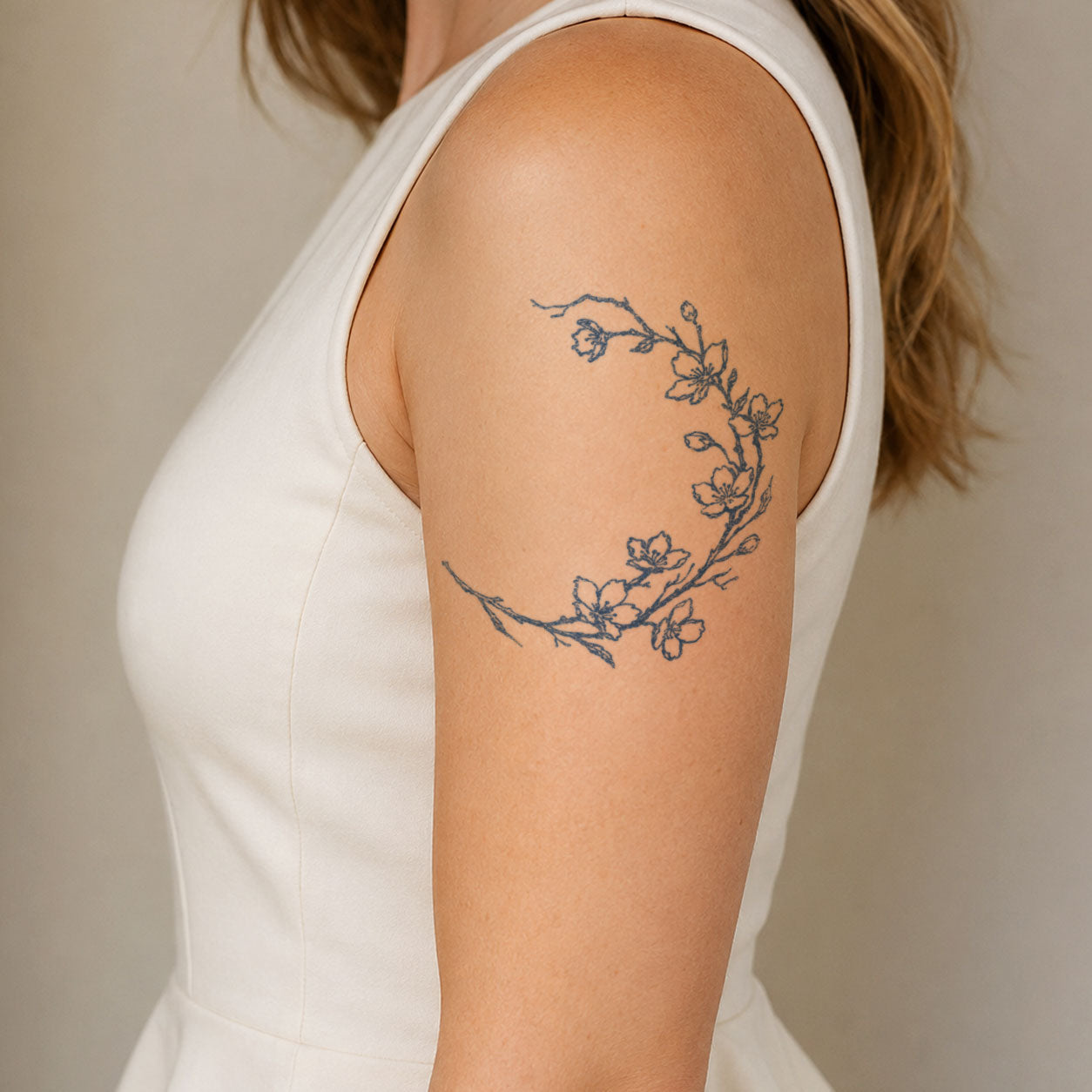 Floral temporary tattoos featuring a delicate flowering branch with open five-petal blooms and small buds on the upper arm.

