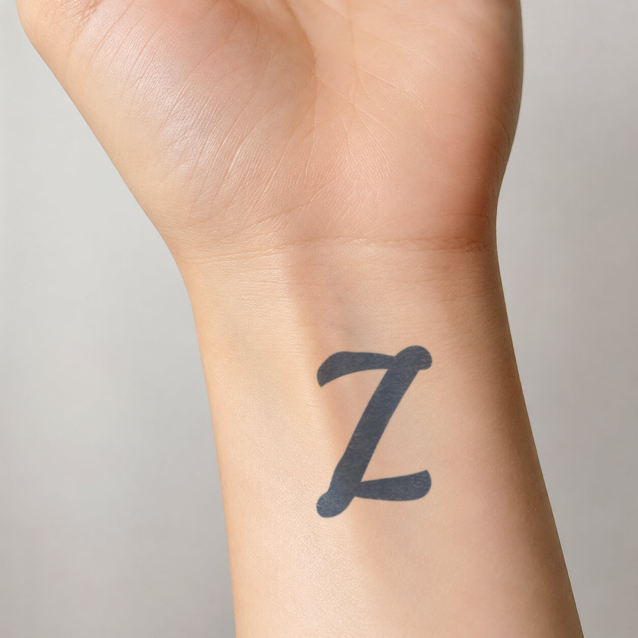 Bold black letter Z design from fake tattoos shown on the inner wrist, with rounded ends and a clean personalized initial style.