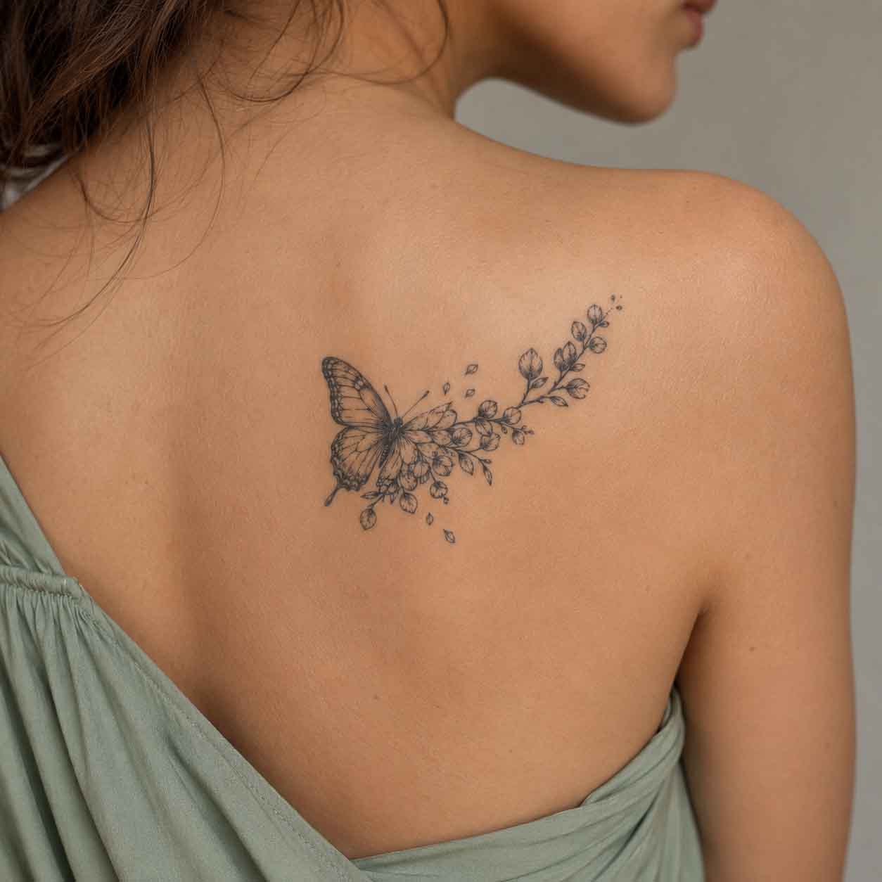 Botanical butterfly fake tattoo applied on upper back with natural elegant styling