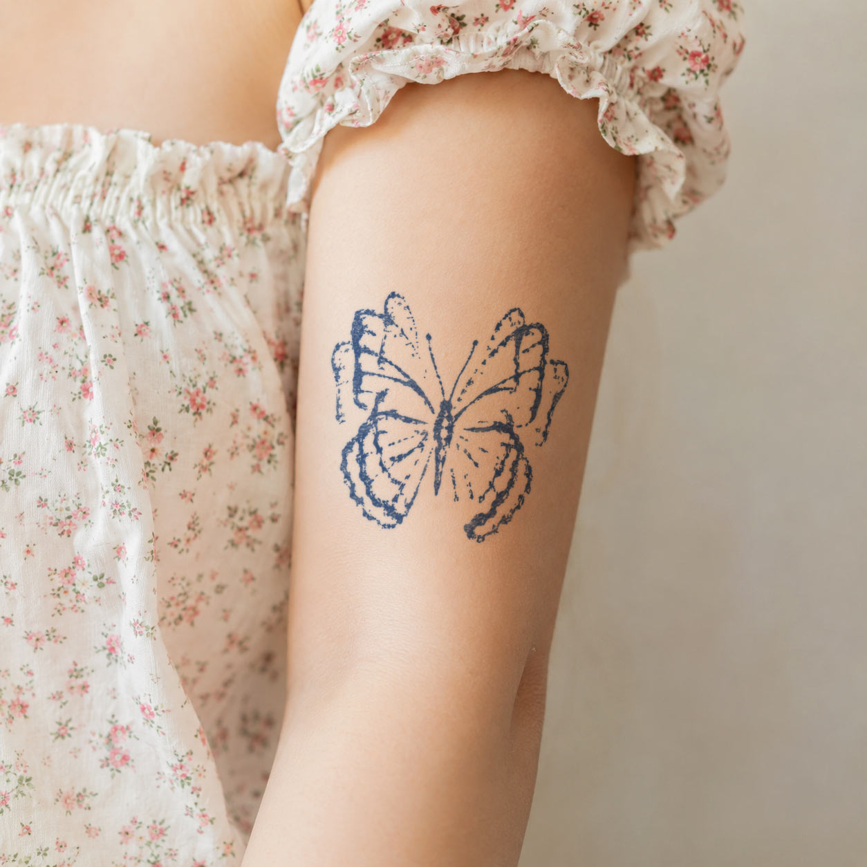 Temporary tattoo design featuring a detailed butterfly with softly textured wings on the upper arm.