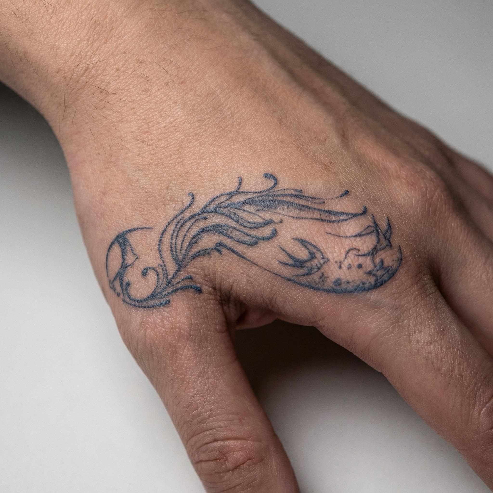 Flowing ocean-inspired temporary tattoo placed on hand
