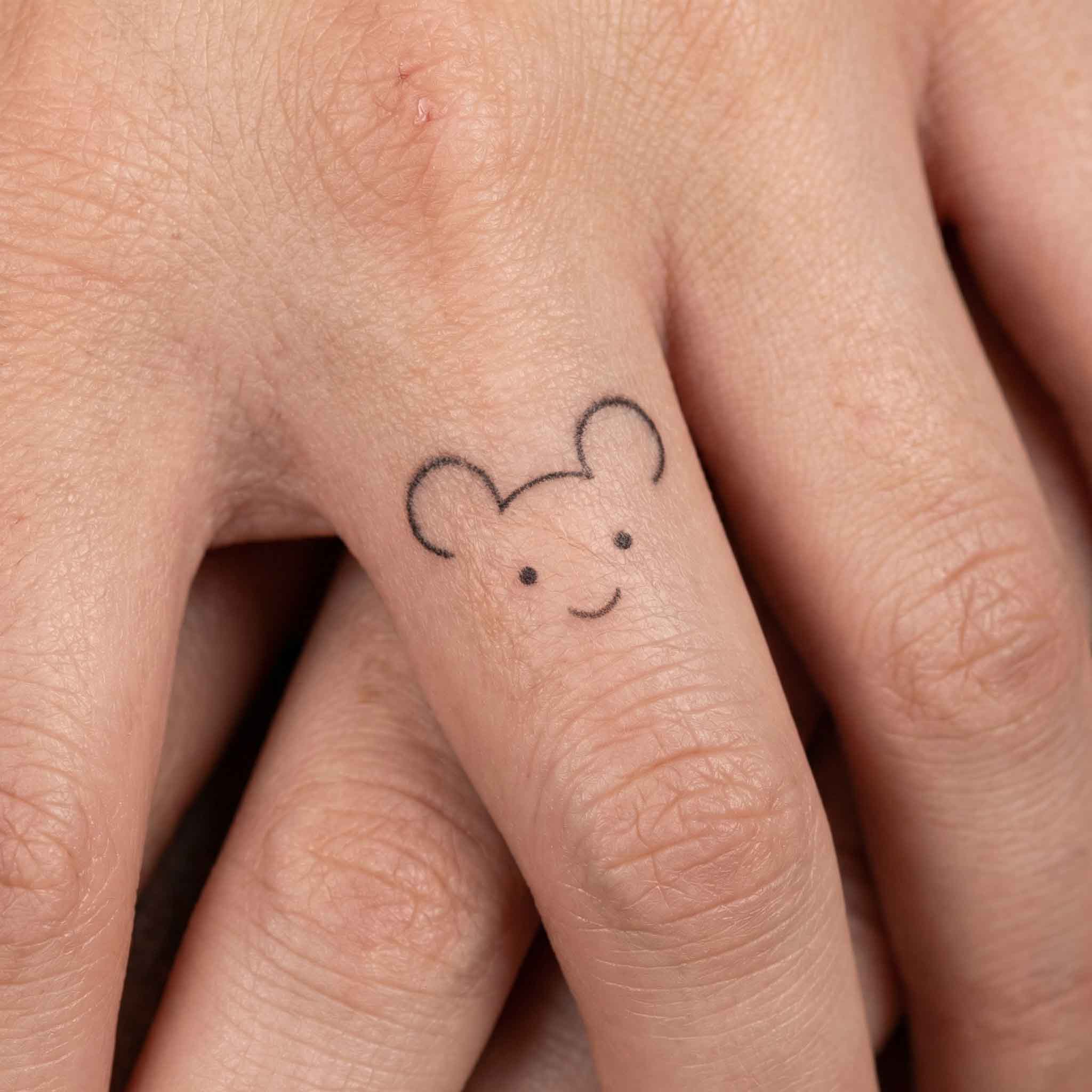 Tiny cute animal temp tattoos worn on finger in minimalist style