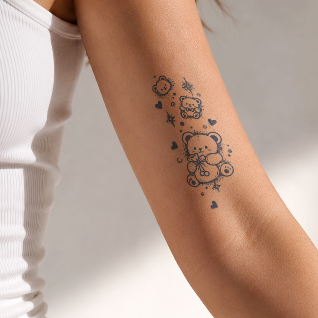 Cute temporary tattoos featuring teddy bears, tiny hearts and sparkling stars on the upper arm.