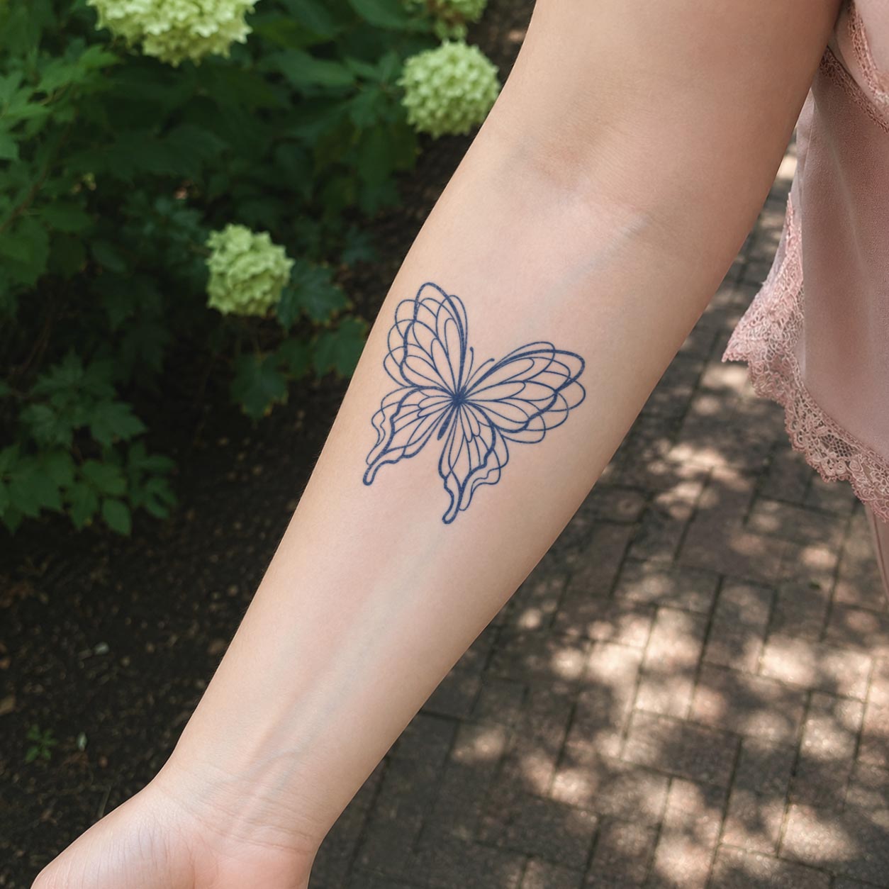 Butterfly temporary tattoo featuring a delicate black line-art butterfly placed on the inner forearm.