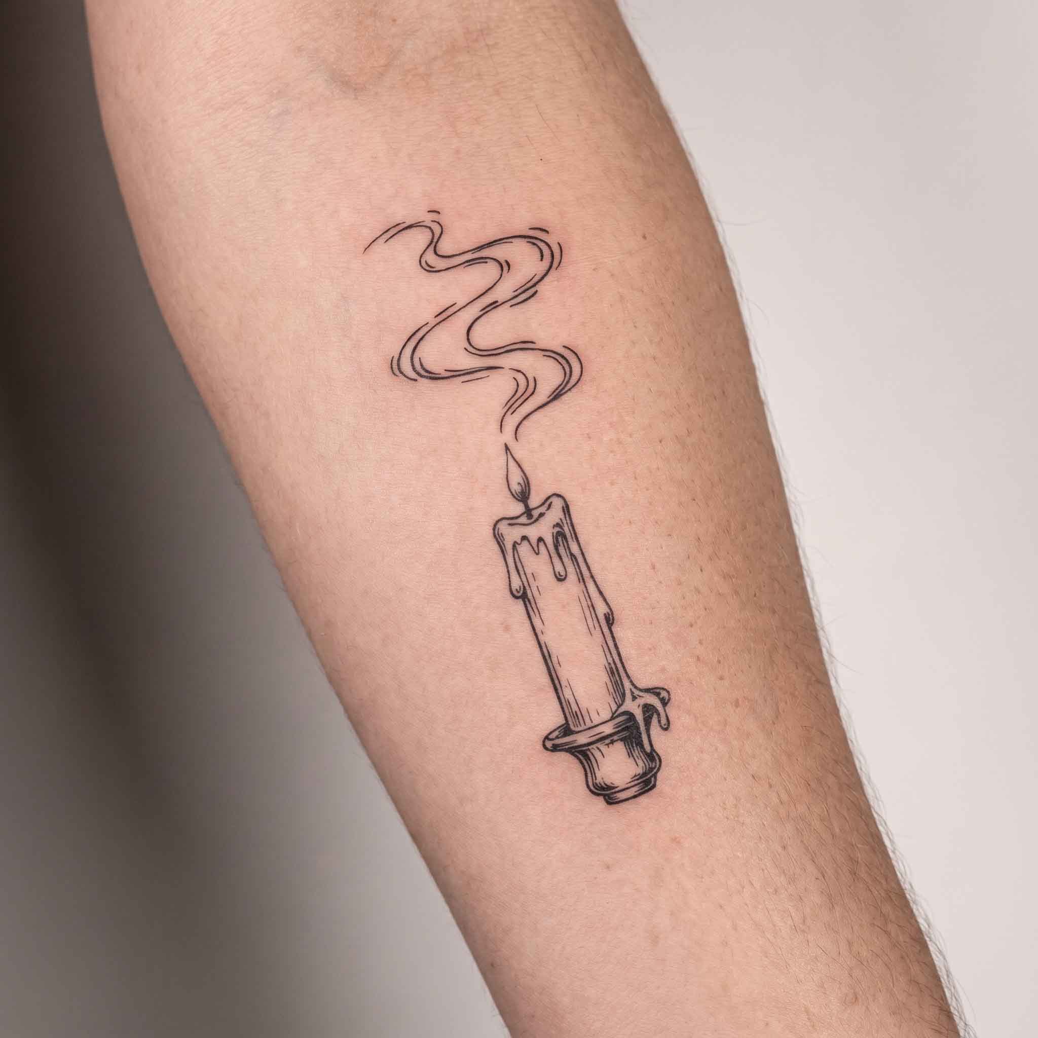 Fine line candle temporary tattoo on arm