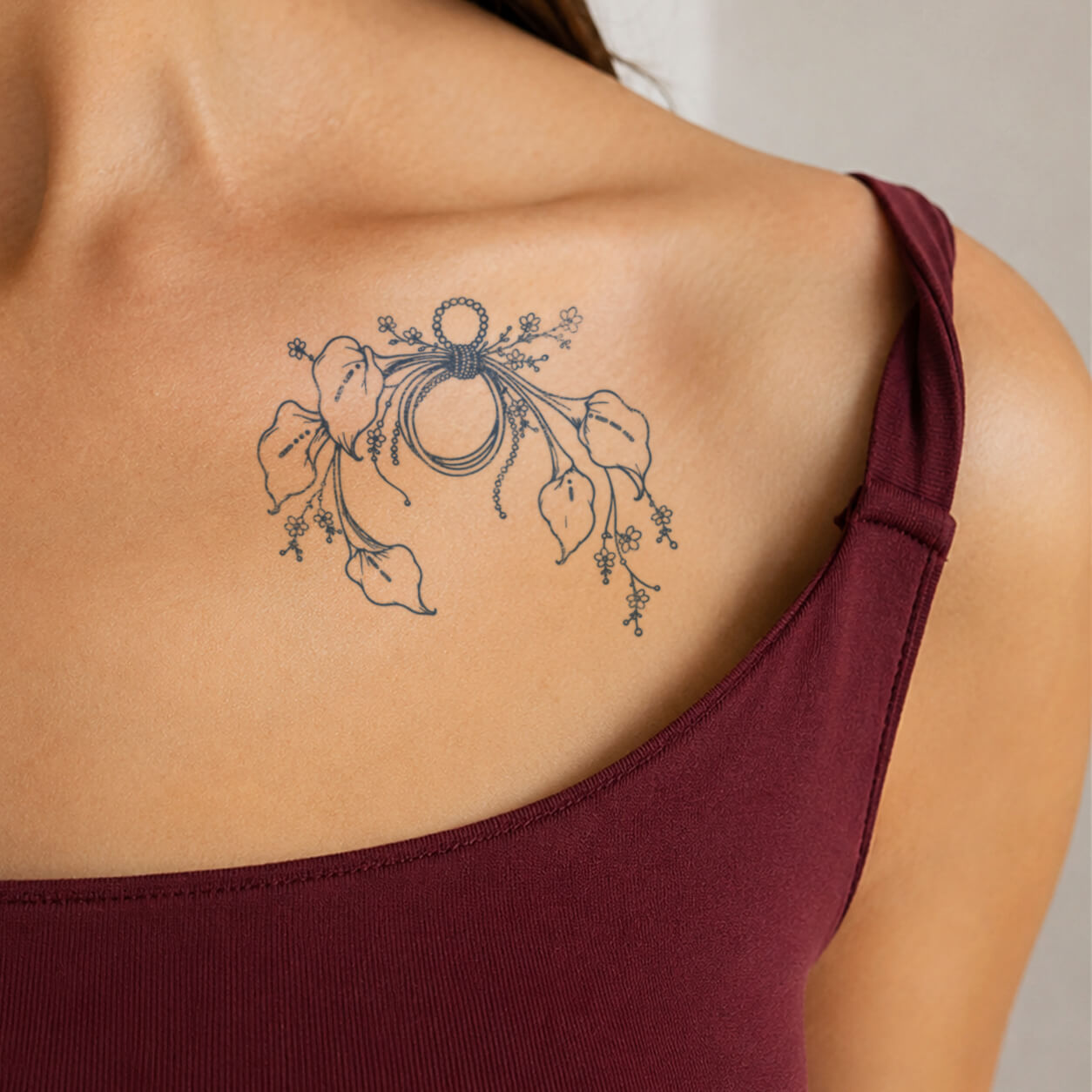 Delicate floral wreath temporary tattoo with botanical leaves and small flowers on the clavicle