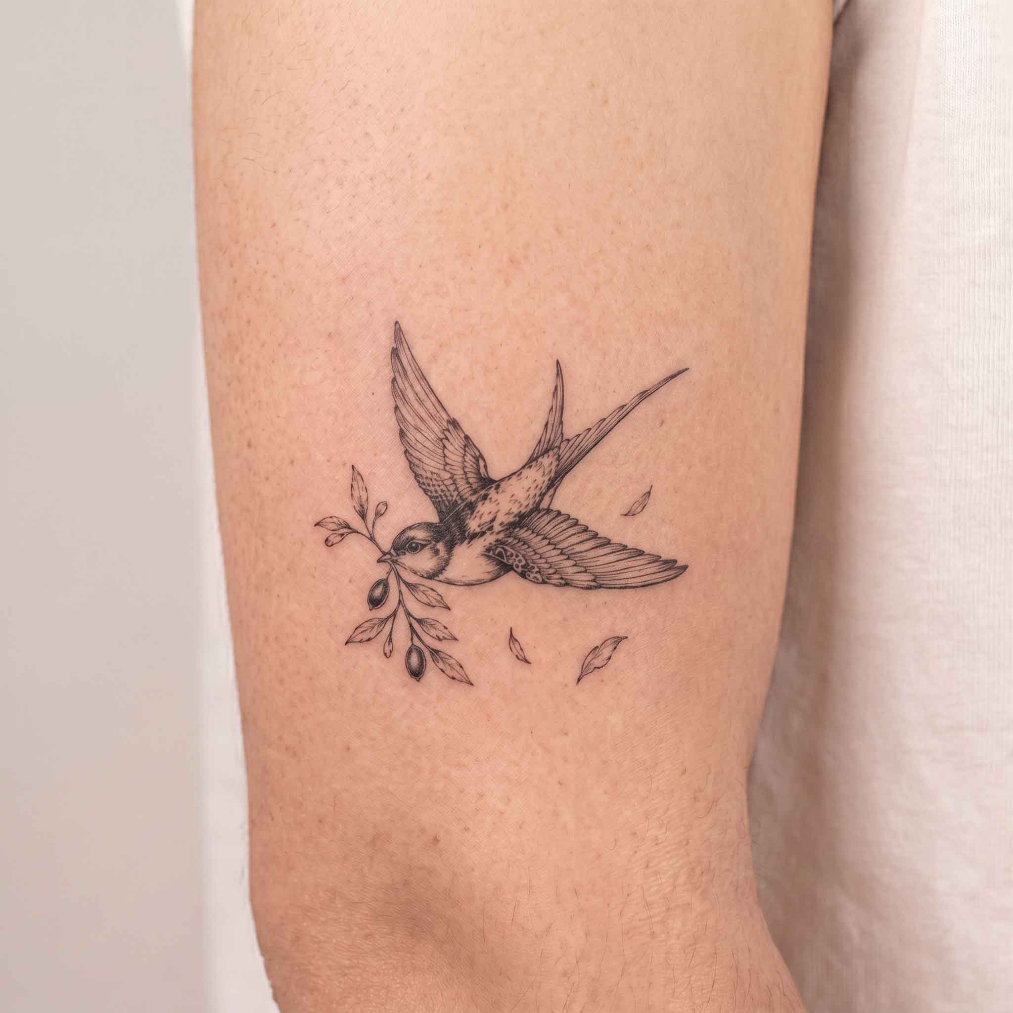 Flying swallow temp tattoo on upper arm