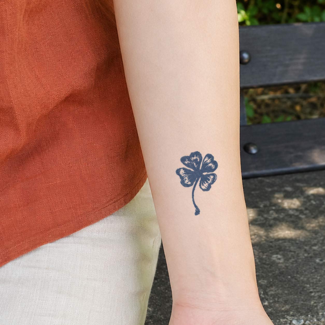 Temporary forearm tattoos featuring a small distressed-ink four-leaf clover on the inner arm.
