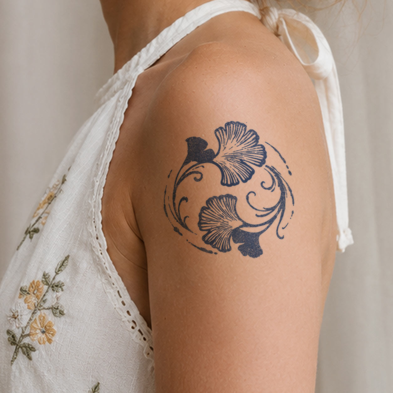 Botanical temporary tattoo featuring delicate ginkgo leaves arranged in a graceful circular wreath on the upper arm.