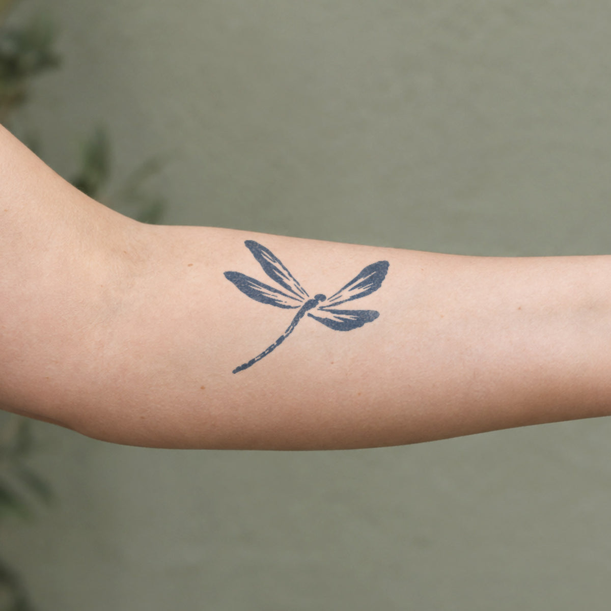 Nature temporary tattoos featuring a detailed dragonfly design in blue-black ink on the inner forearm.