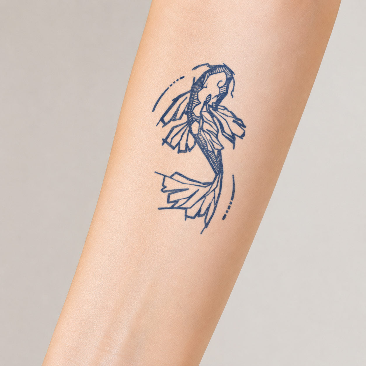 Semi-permanent tattoo featuring a flowing koi fish design with elegant curved lines on the inner forearm.