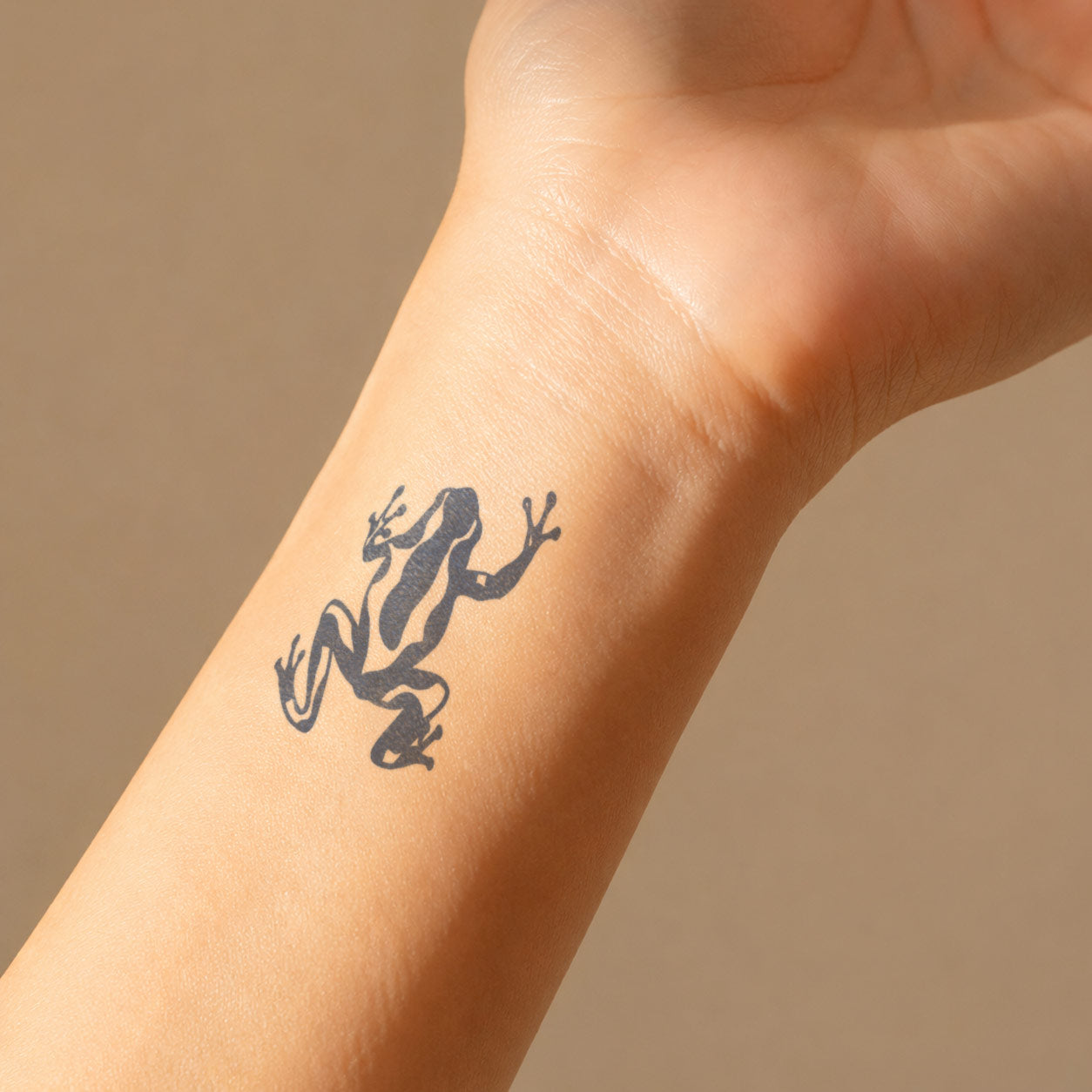 Small semi-permanent tattoo featuring a bold black frog mid-leap, placed on the inner wrist for a playful nature-inspired look.
Abstract Botanical Semi-Permanent Tattoo