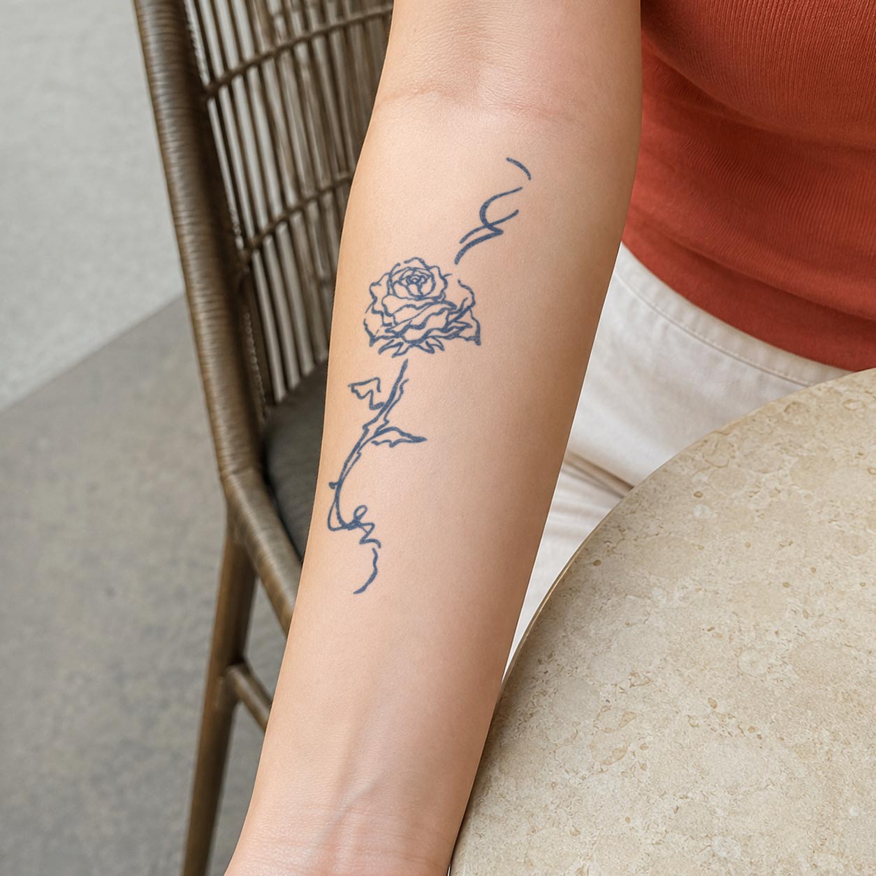 Temporary forearm tattoos featuring a minimalist line-drawn rose with a long curving stem and leaves.