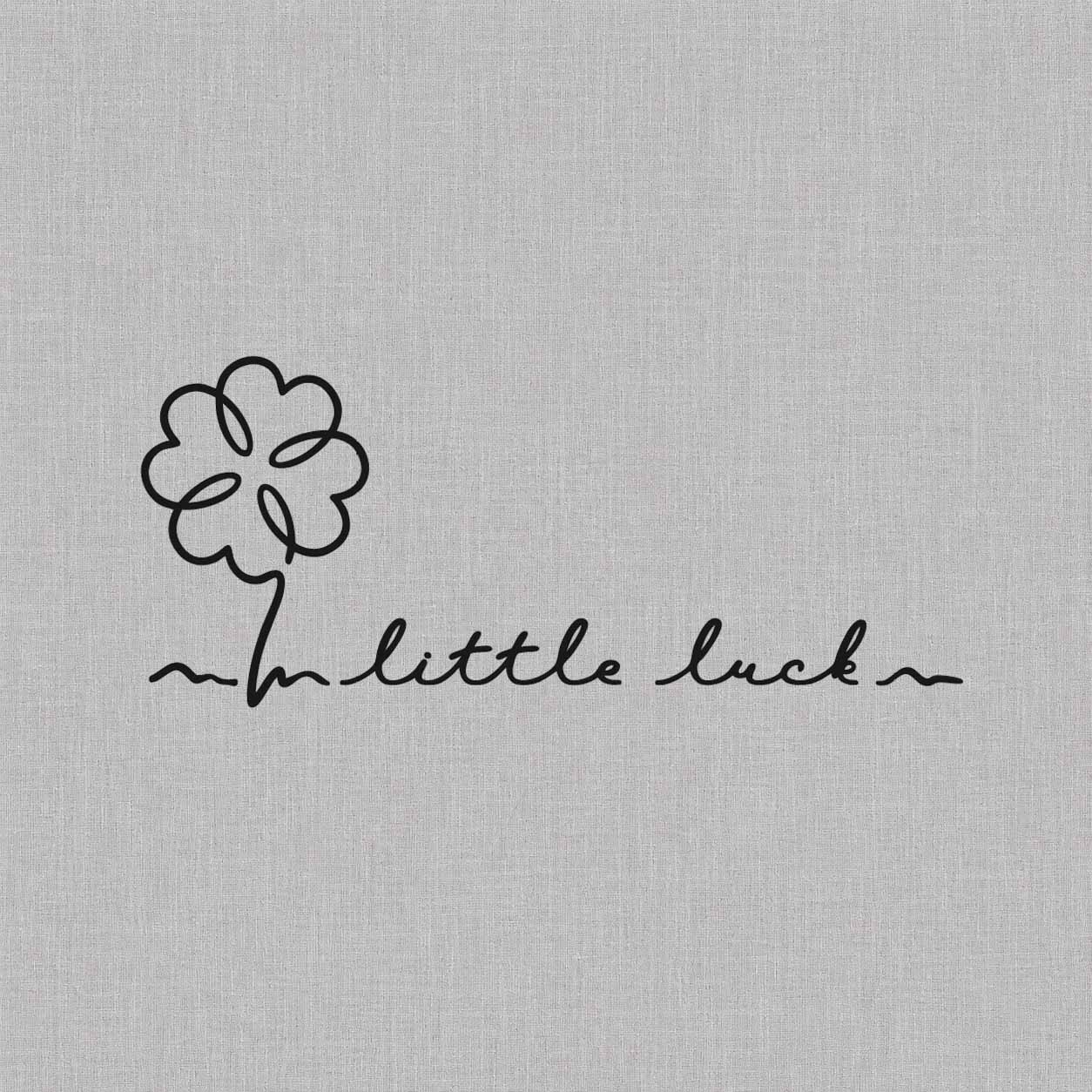 Little Luck clover temporary tattoo with a minimalist four-leaf clover and handwritten script lettering.
