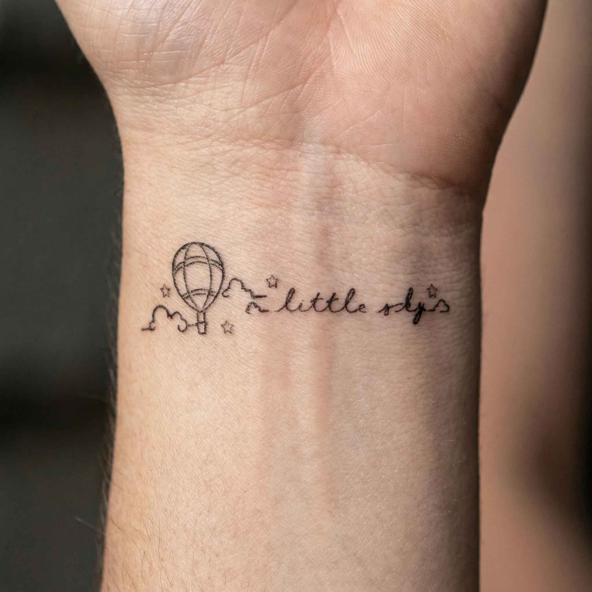 Tiny balloon fine line fake tattoos worn on wrist 