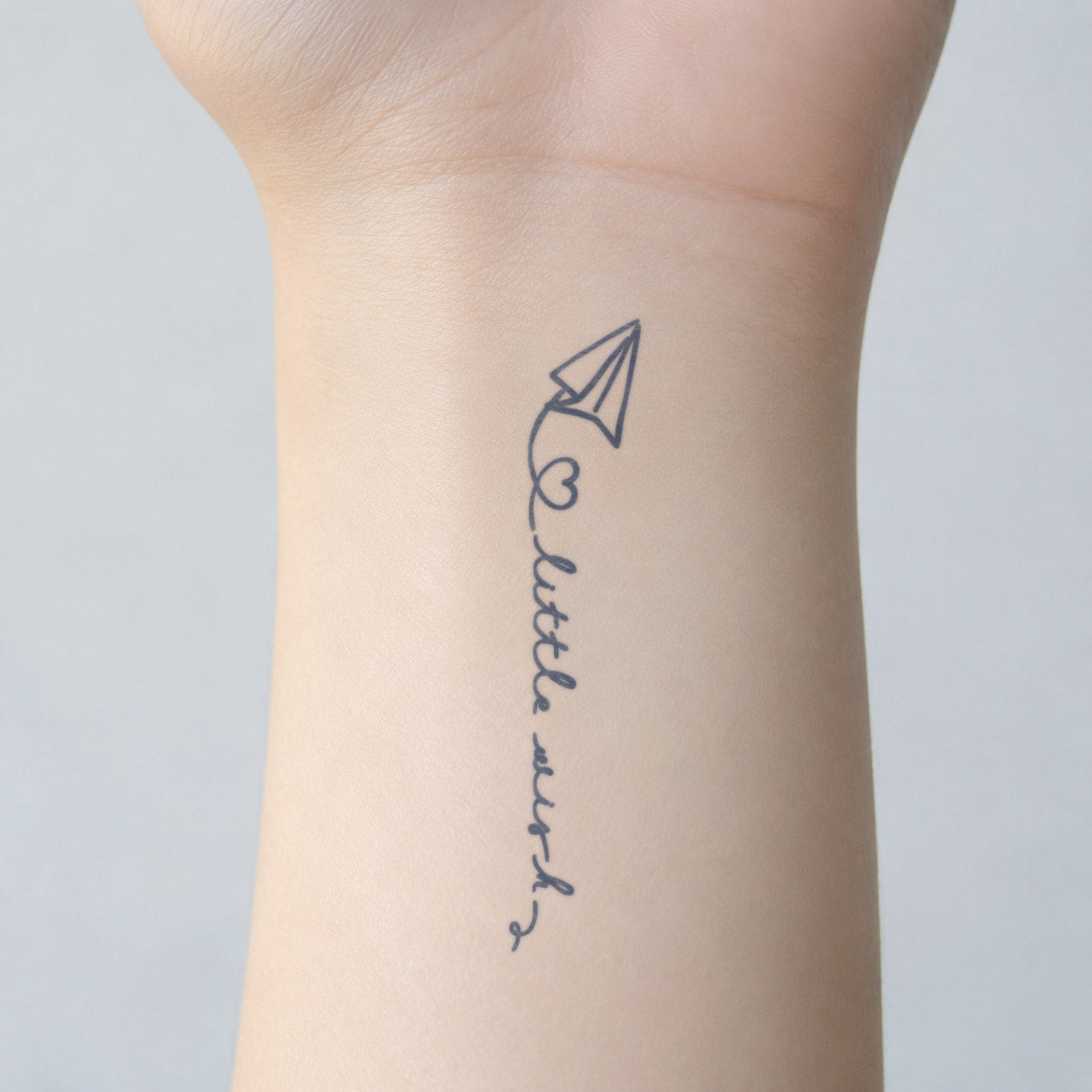 Little Wish Paper Airplane Semi-Permanent Tattoo
Inspirational temporary tattoo featuring a paper airplane, a small heart, and “little wish” handwritten lettering on the inner wrist.