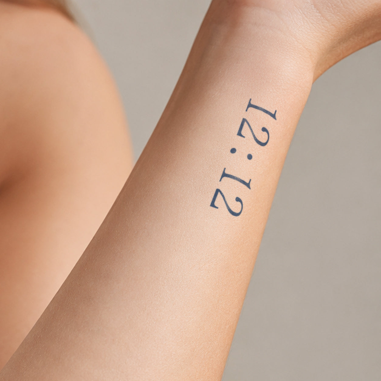 Minimal 12:12 temporary tattoo featuring clean black numbers and dot separators on the wrist, creating a simple time-inspired design with a modern and meaningful style