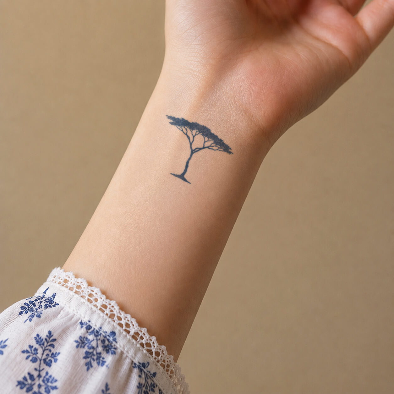 Simple line art tattoo featuring a lone acacia tree silhouette with a wide canopy and delicate branches on the wrist. A minimalist temporary tattoo inspired by African landscapes, nature, and peaceful outdoor scenery.