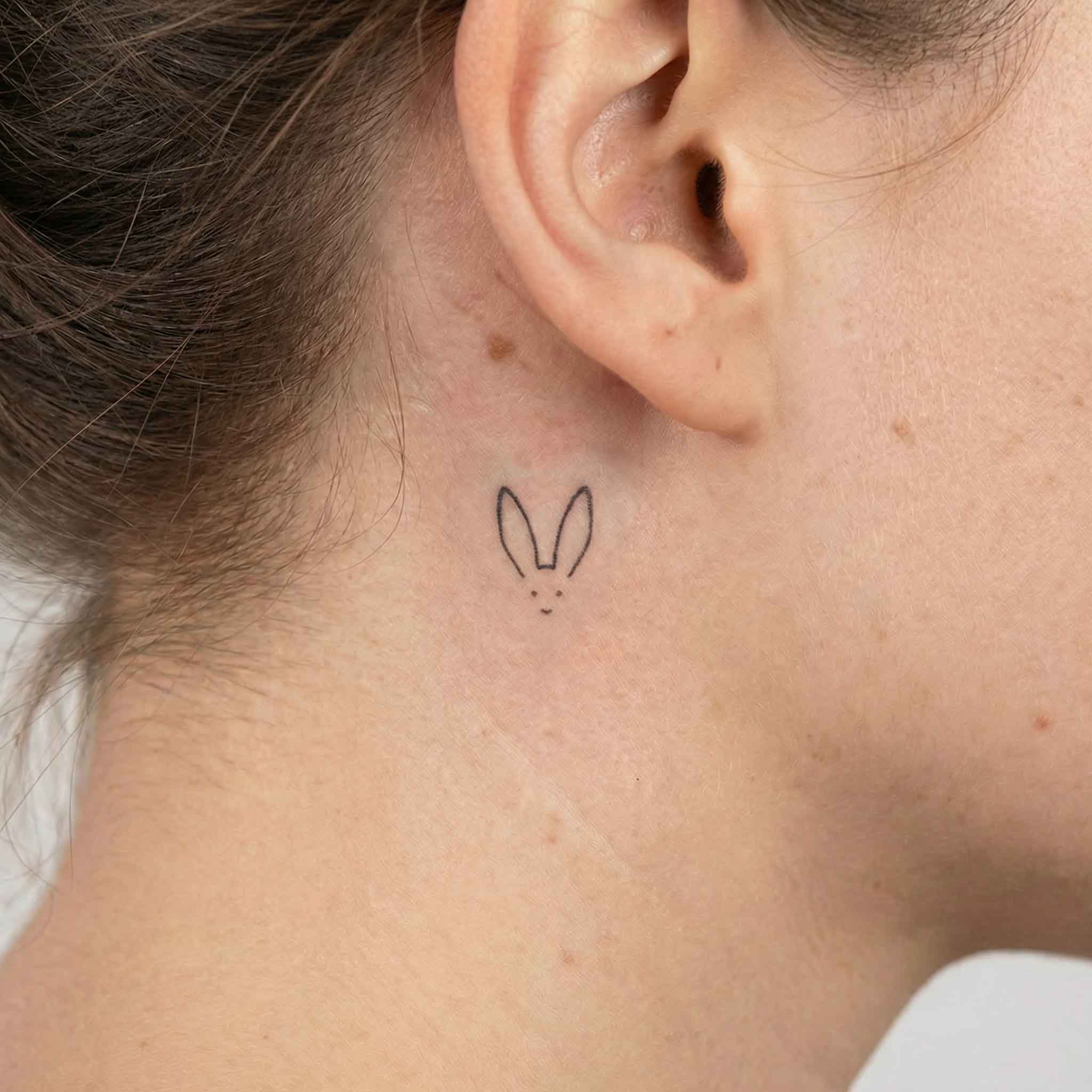 Tiny minimalist rabbit temp tattoos behind ear