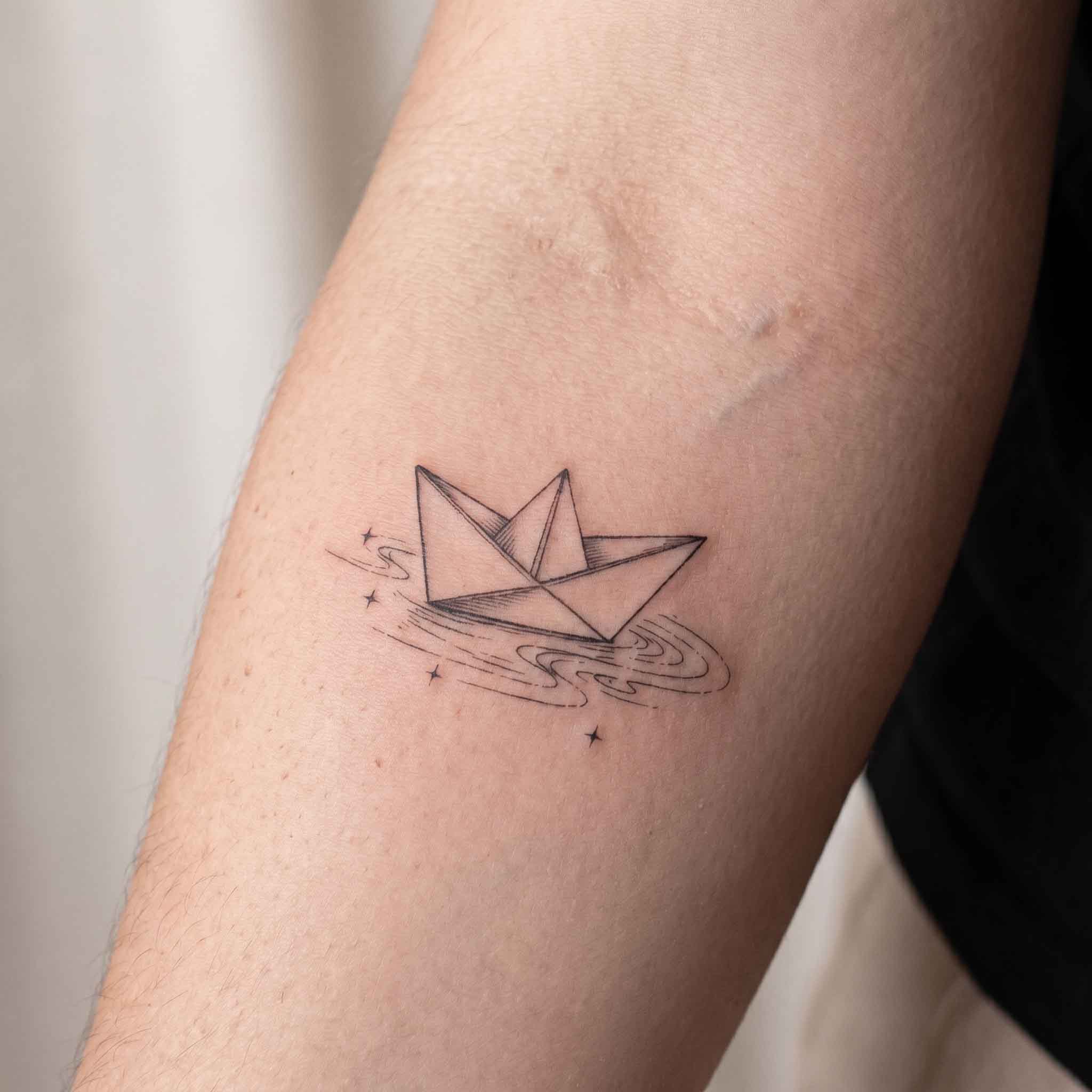 Paper boat semi-permanent tattoo on forearm