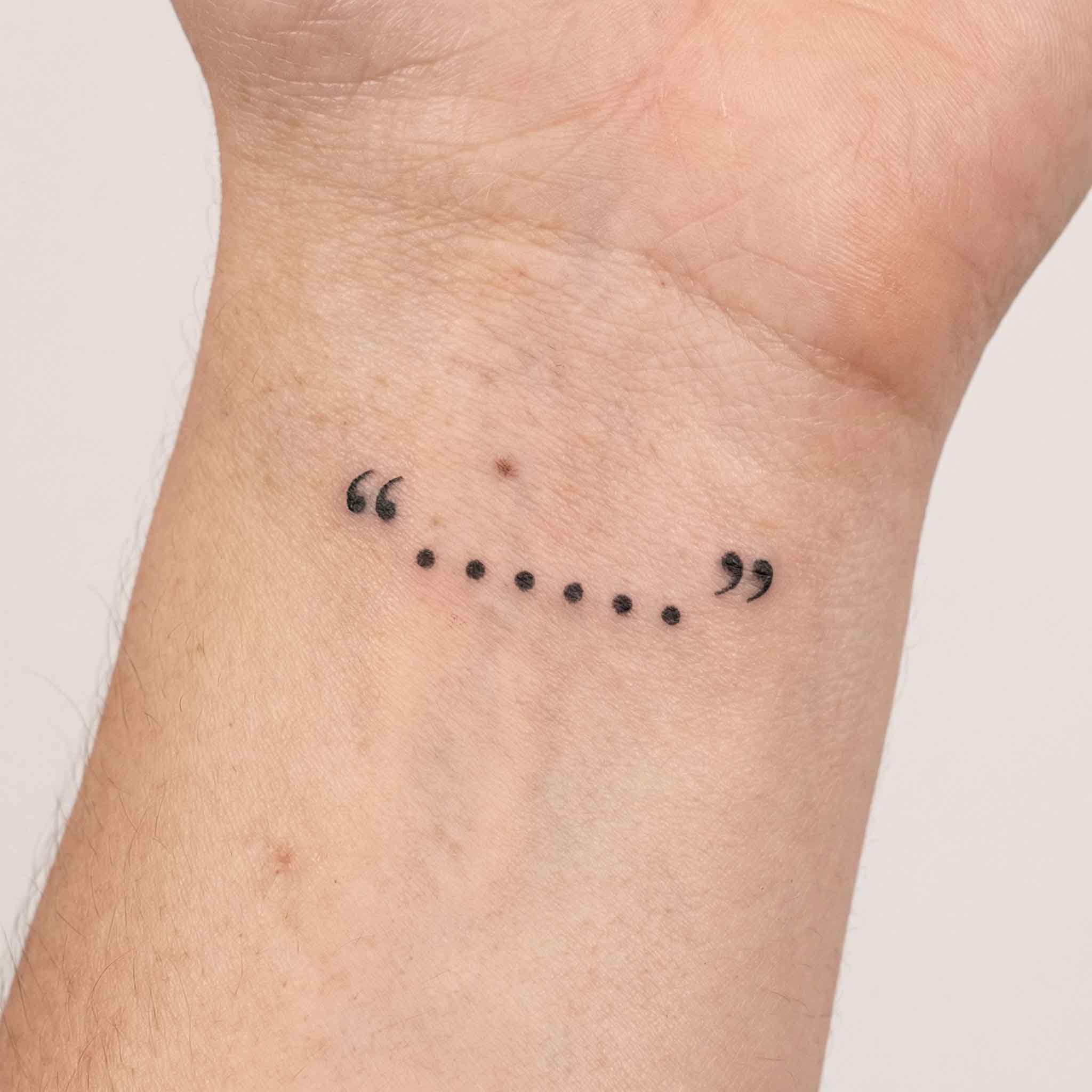 Minimal punctuation tattoo worn on the wrist