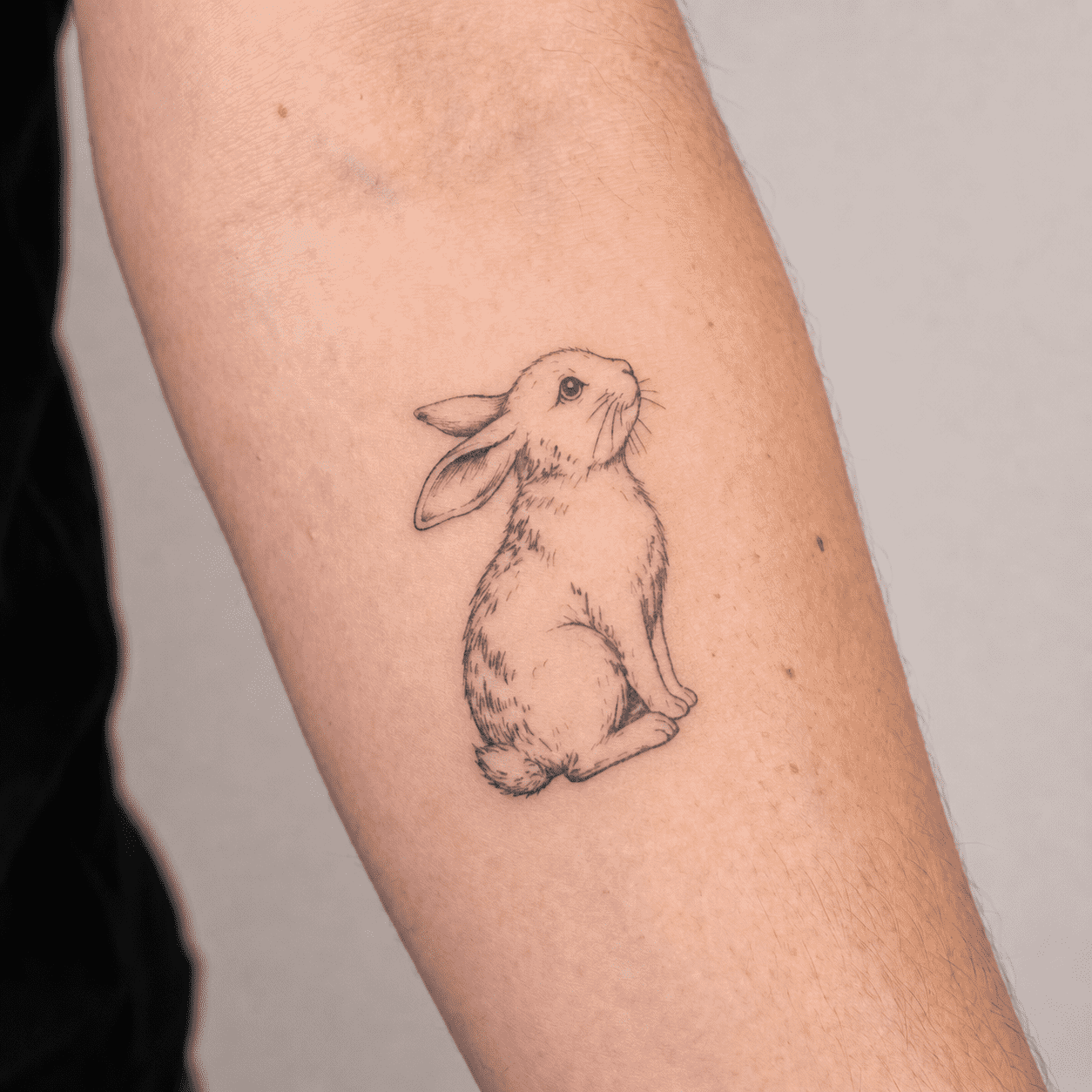 Rabbit fine line temporary tattoo on forearm
