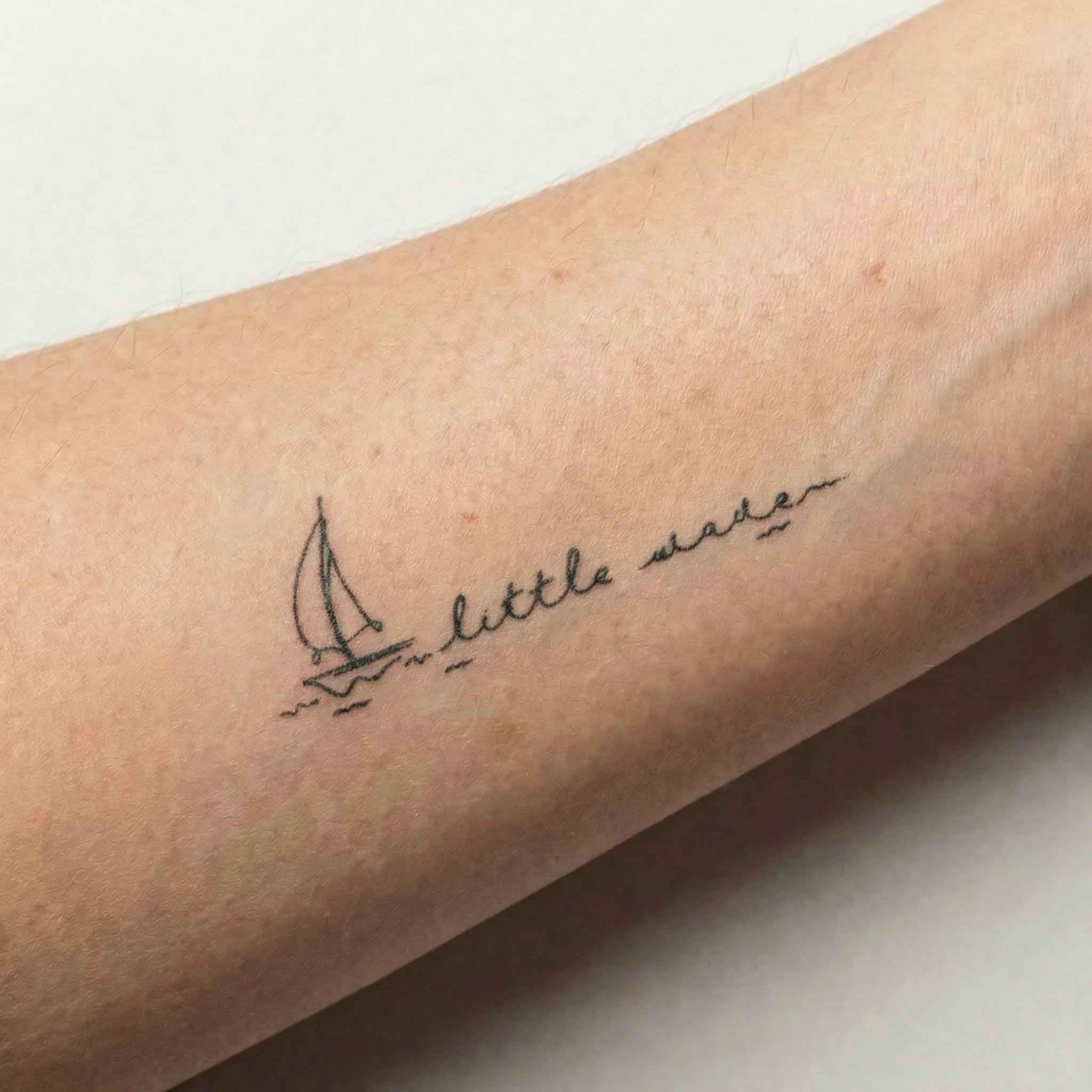 Mini Series sailboat and word temporary tattoo shown on skin.