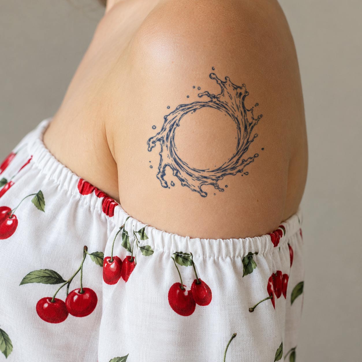Temporary tattoo featuring a dynamic circular water splash design on the upper arm.