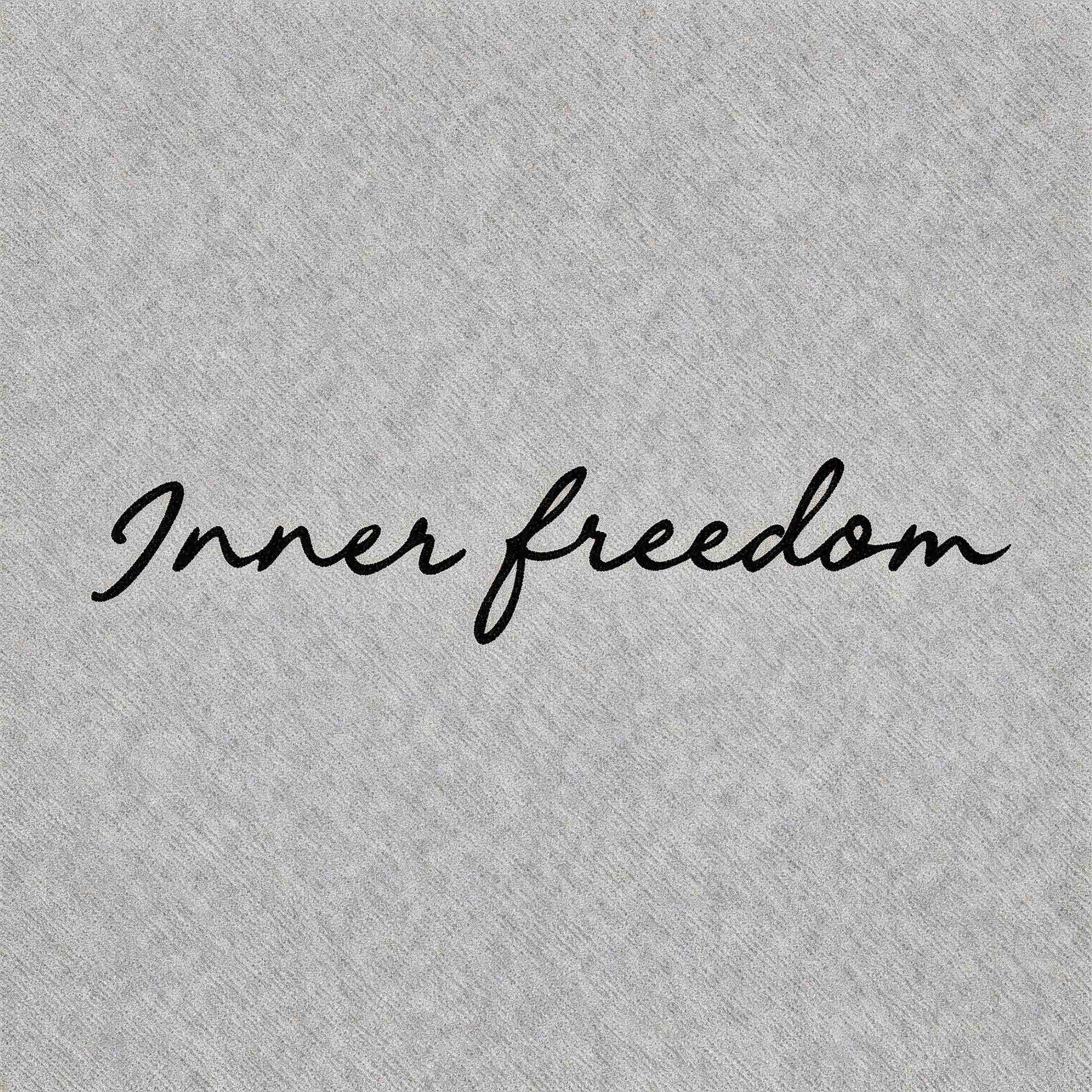 A black cursive script logo of the phrase "Inner freedom" in an elegant, flowing handwritten font, centered on a light grey textured background.