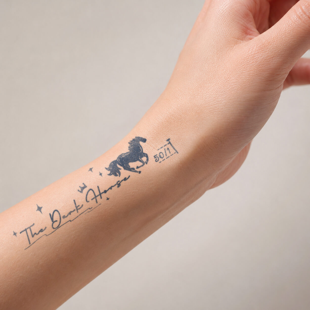 Handwritten quote design with a running horse silhouette and star details placed on the wrist, featuring a meaningful horse temporary tattoo with an artistic minimal style.