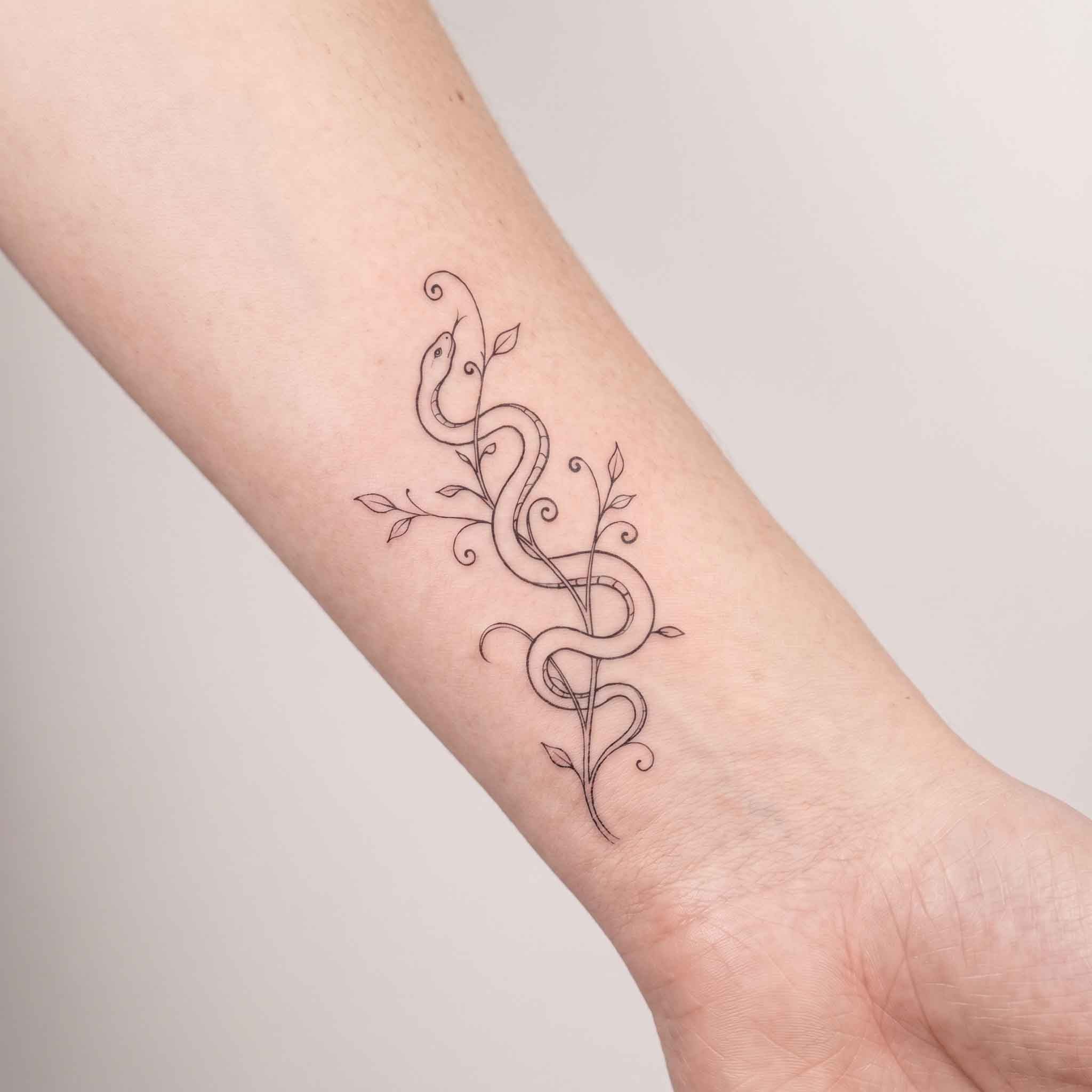 Wearing symbolic serpent herbal semi-permanent tattoo on wrist