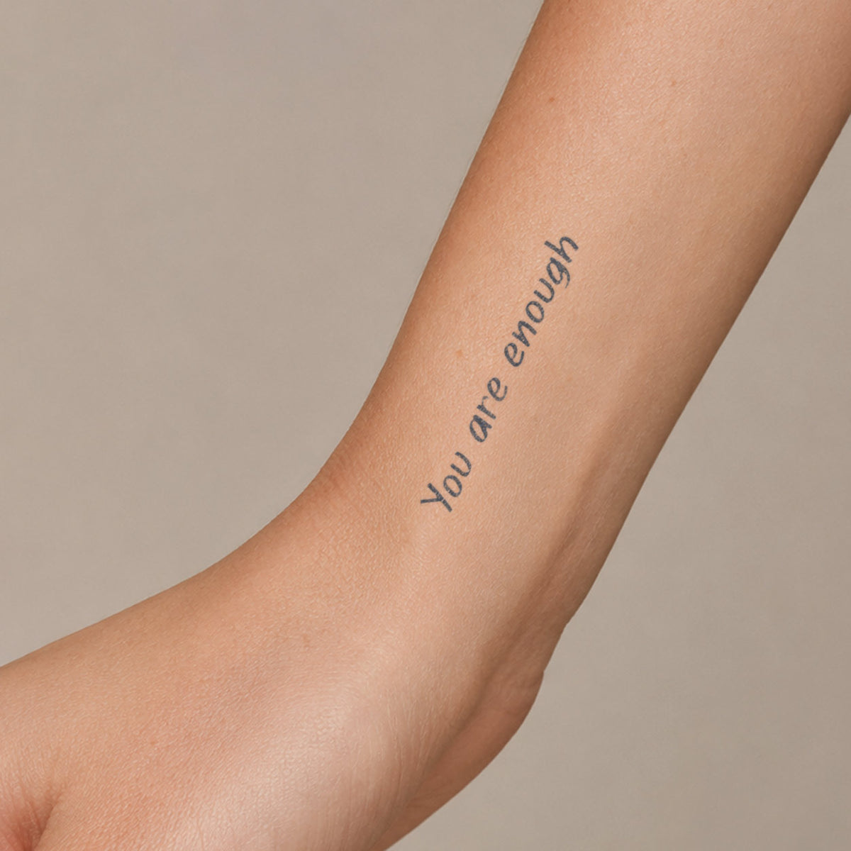 Temporary word tattoos featuring the inspirational phrase “You are enough” in a clean minimalist font on the inner forearm.