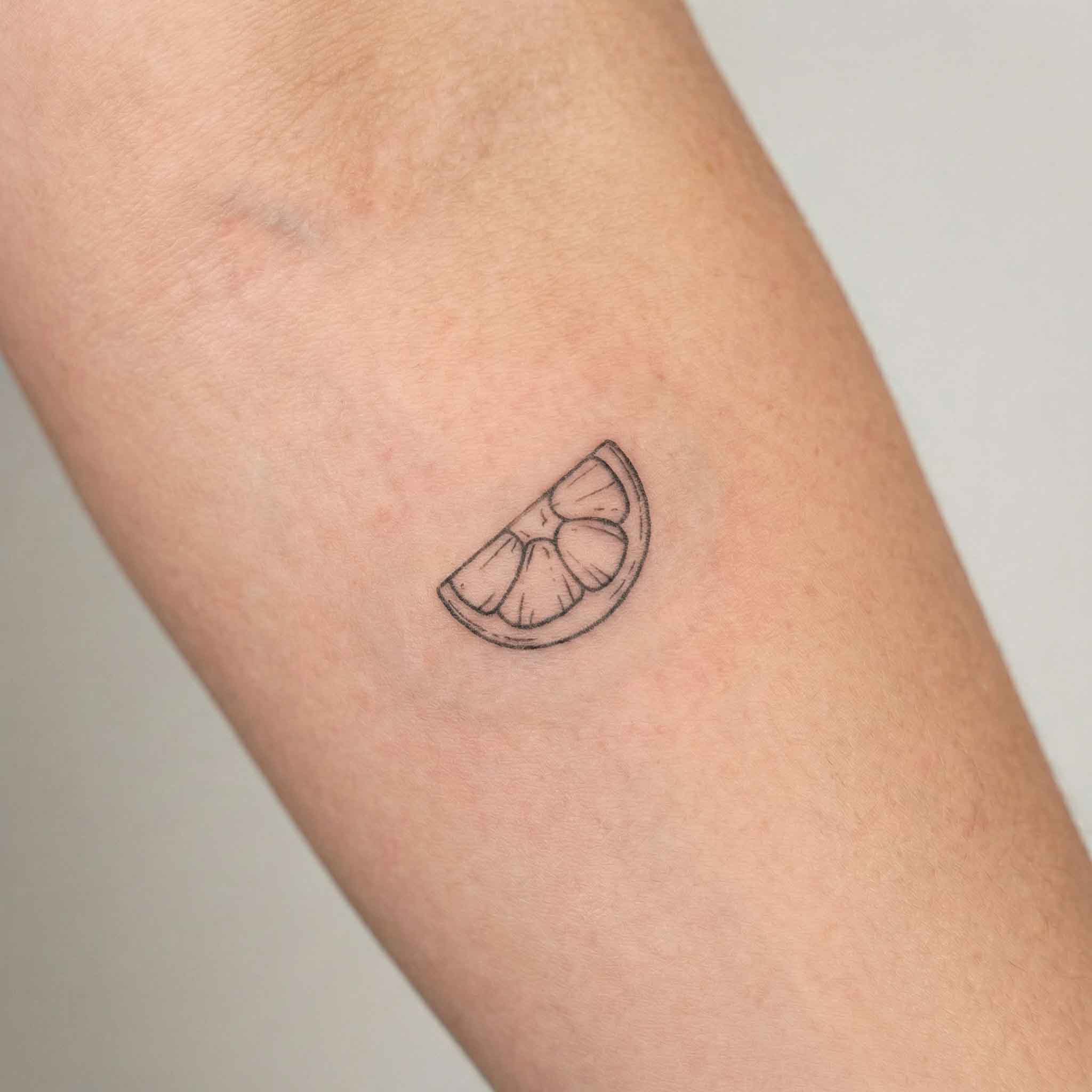 Minimal citrus temp tattoo worn on the wrist 