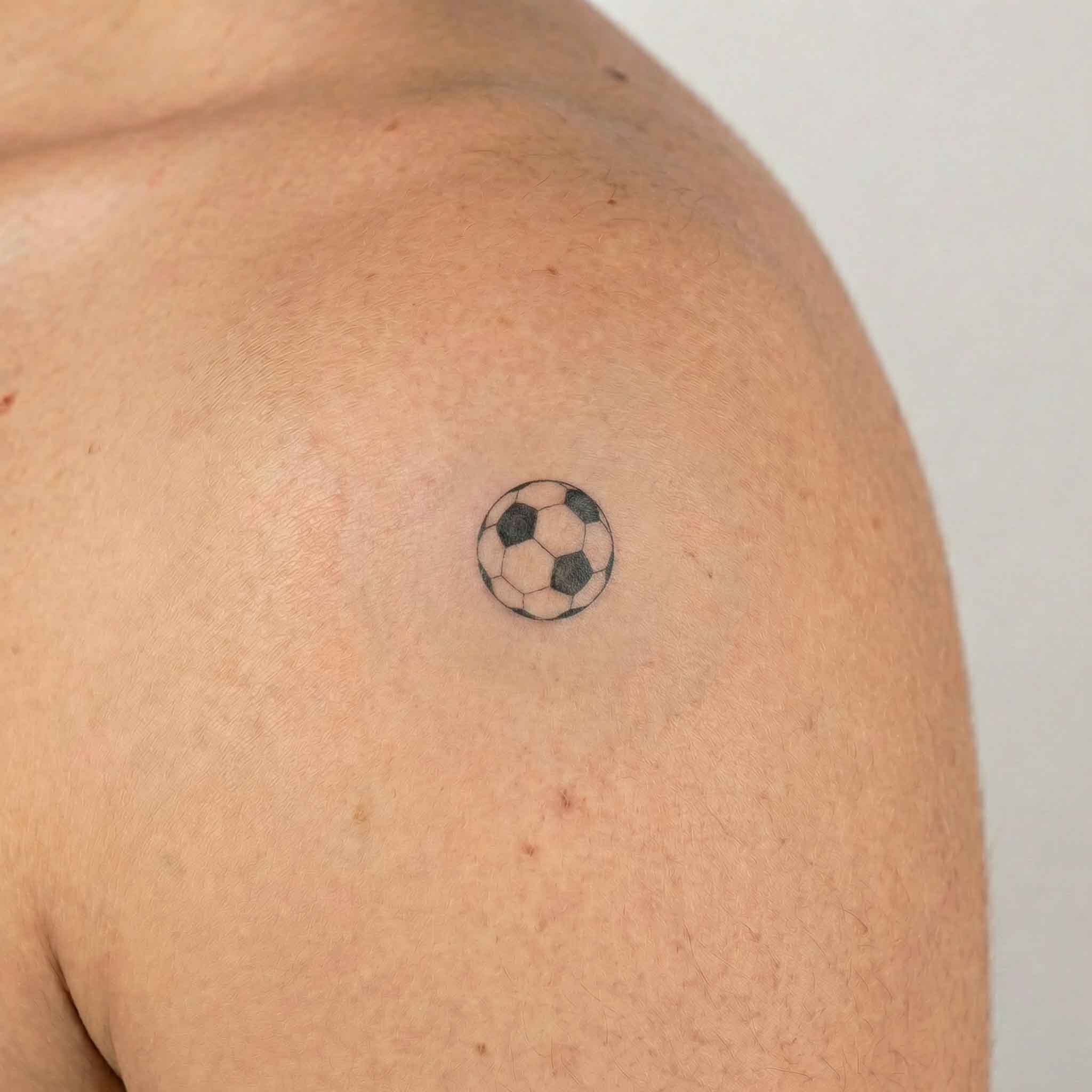 Small football fake tattoo worn on the arm for a simple fan-inspired look