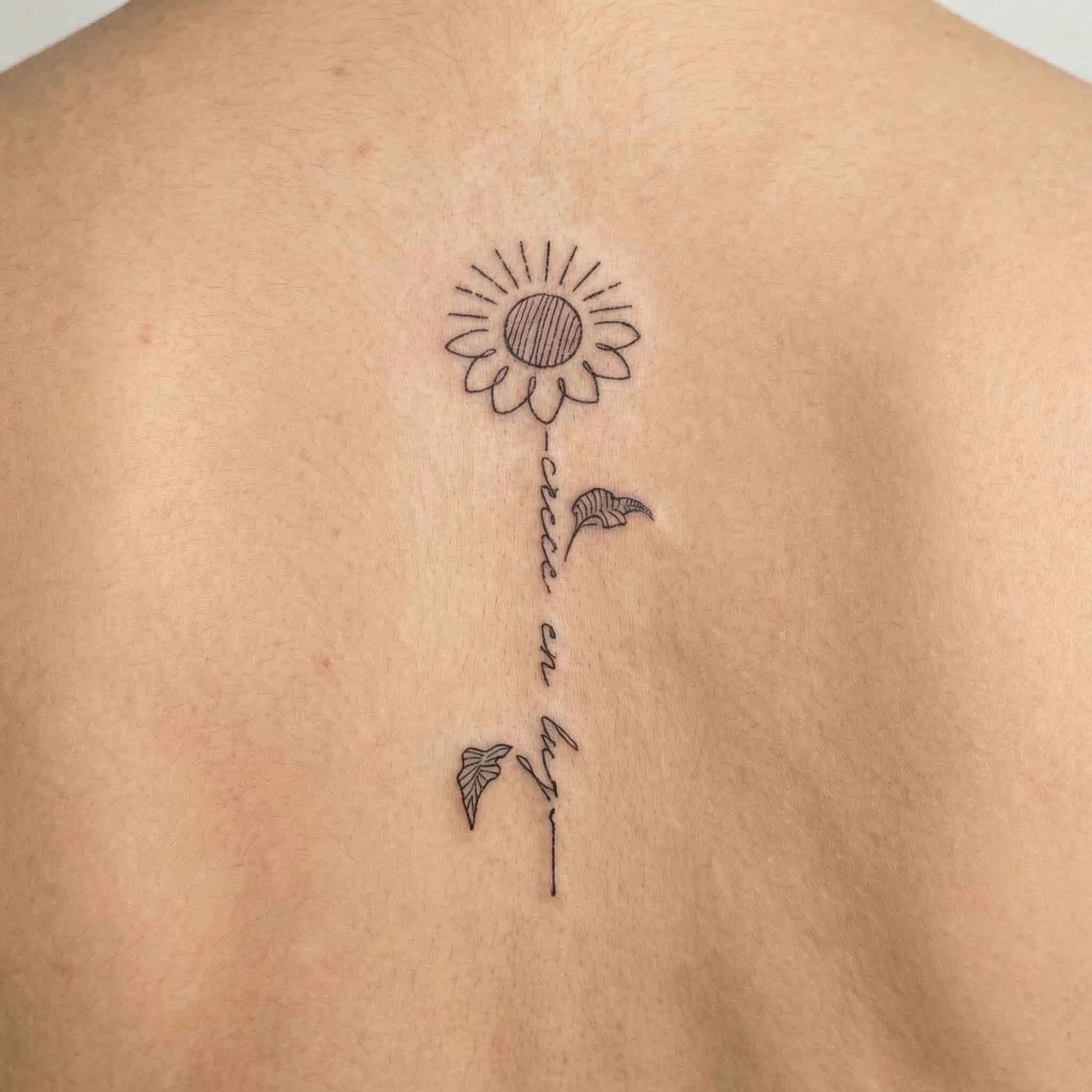 Sunflower floral fake tattoo worn on the back with simple word