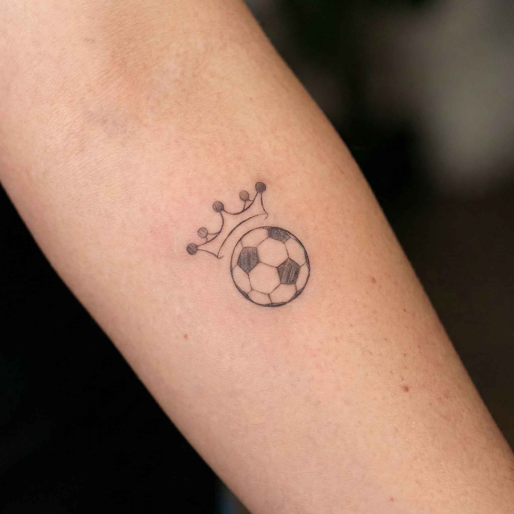 Small crowned football temp tattoo on the arm with clean athletic line work