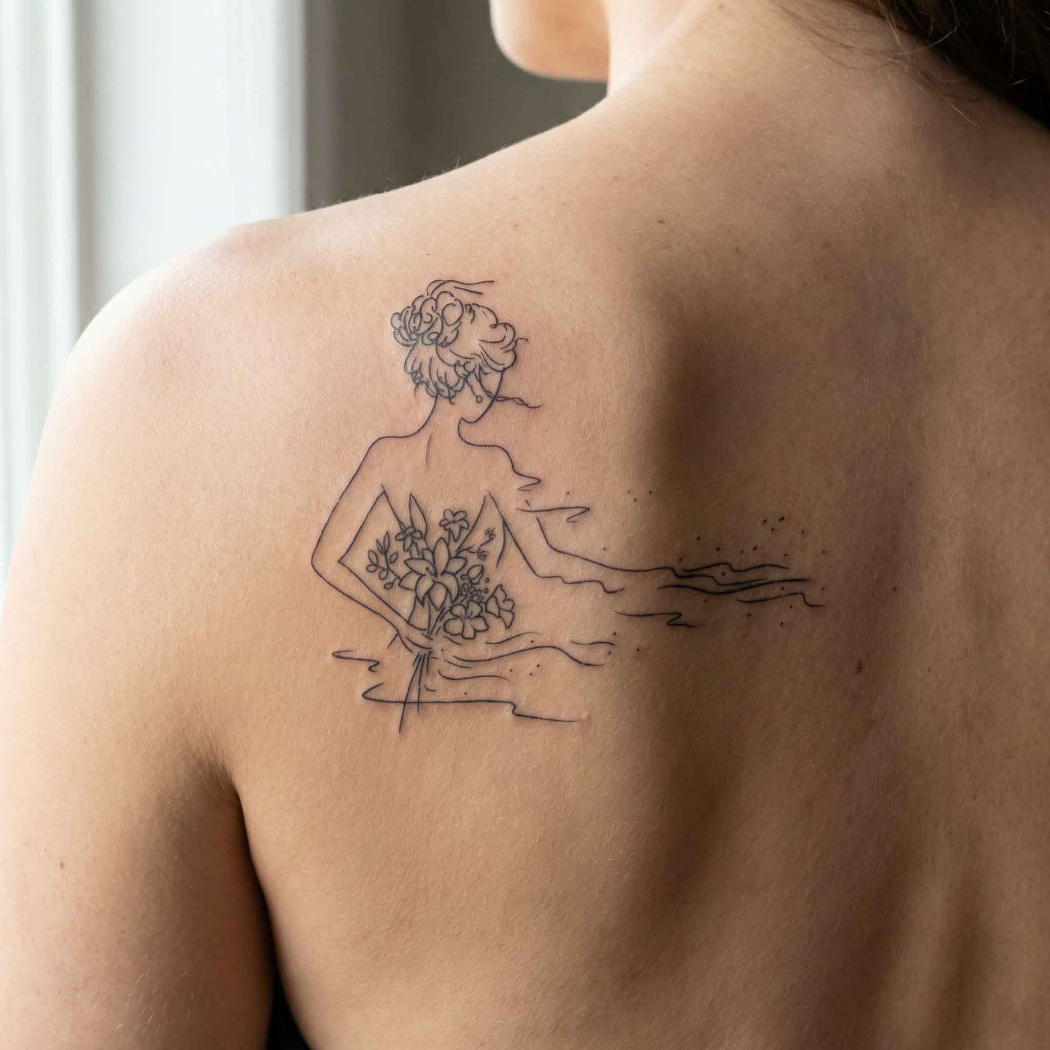 Elegant woman floral temporary back tattoos shown on skin.
