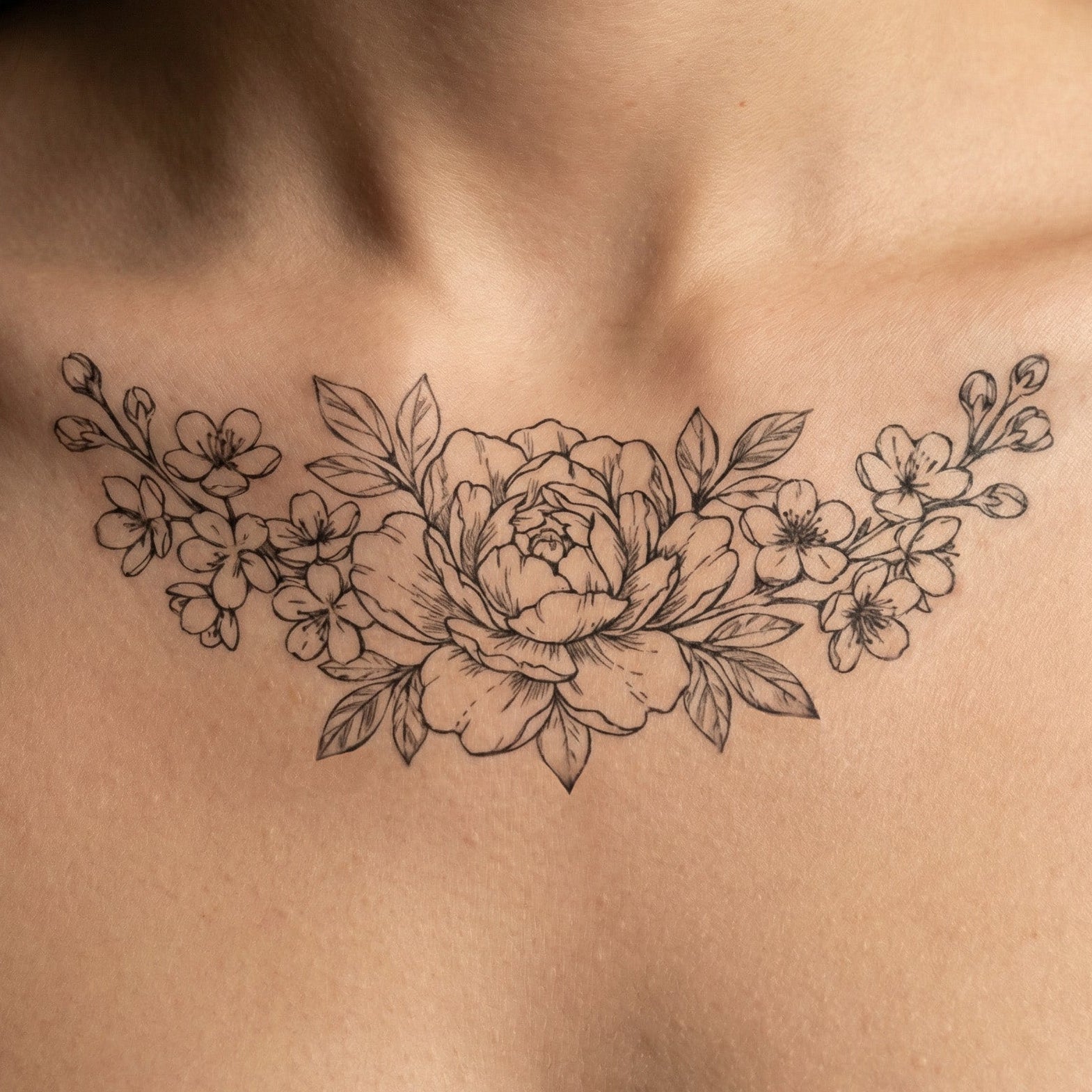 Elegant peony flower tattoo worn on clavicle with botanical details