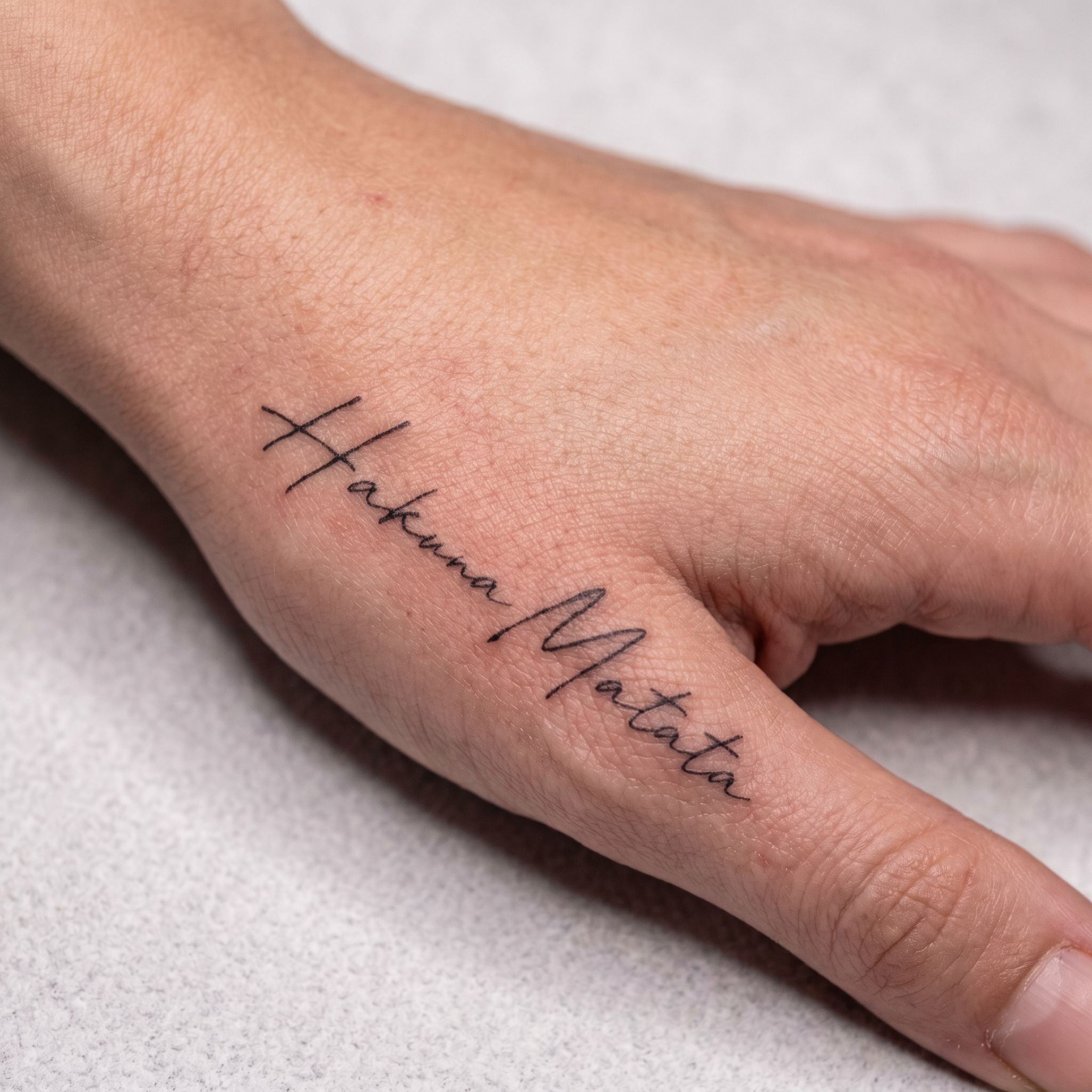 hand placement hakuna matata lettering temporary tattoo 