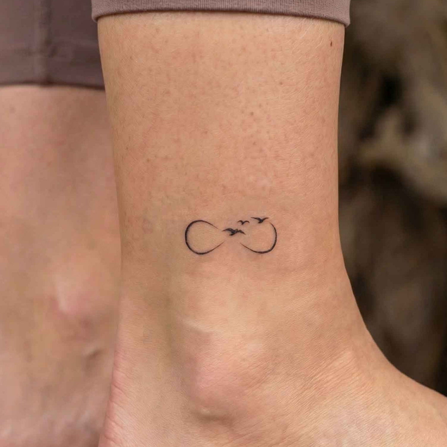 Infinity birds 2 week tattoo shown on skin.