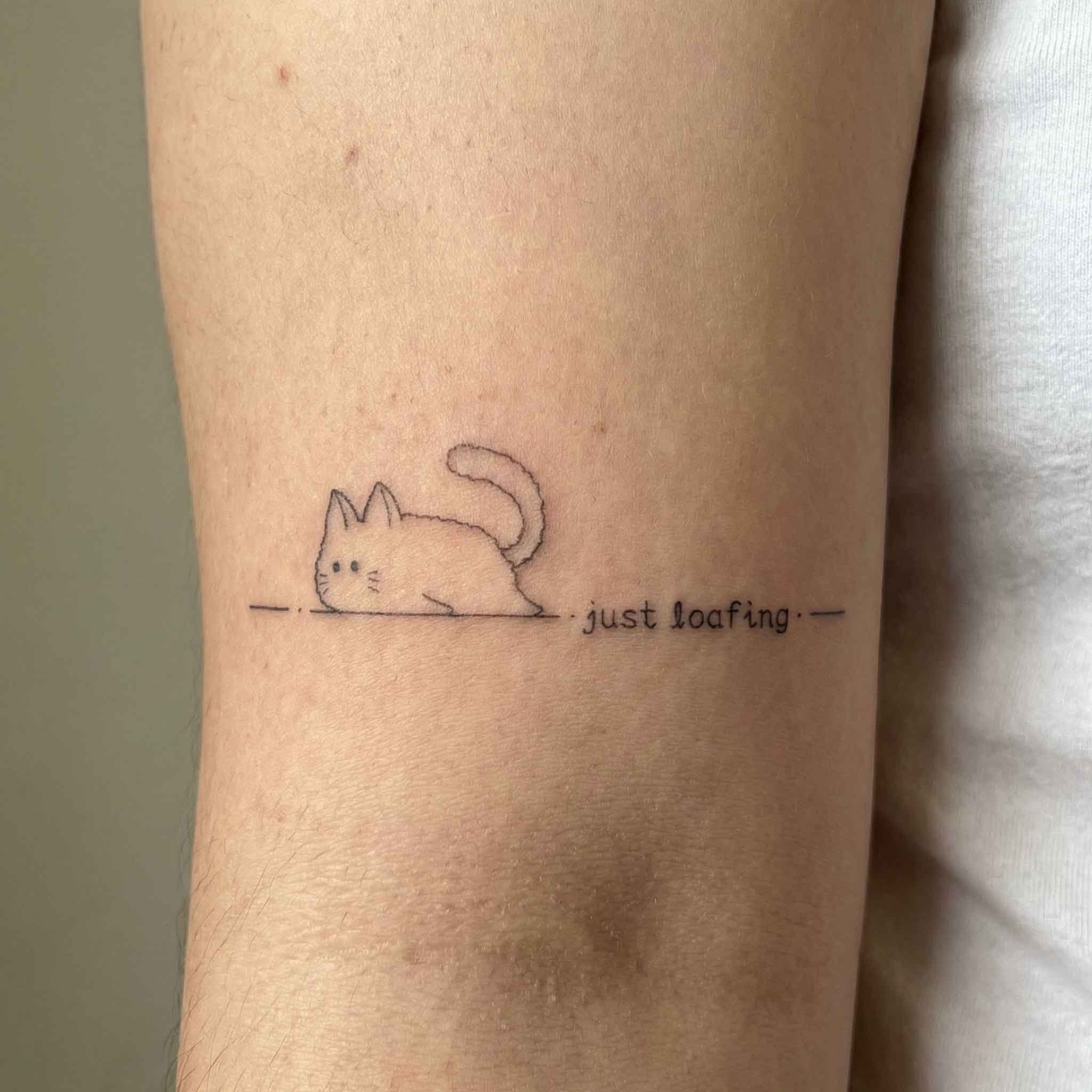 Cute cat temp tattoo worn on the arm with playful minimal lettering