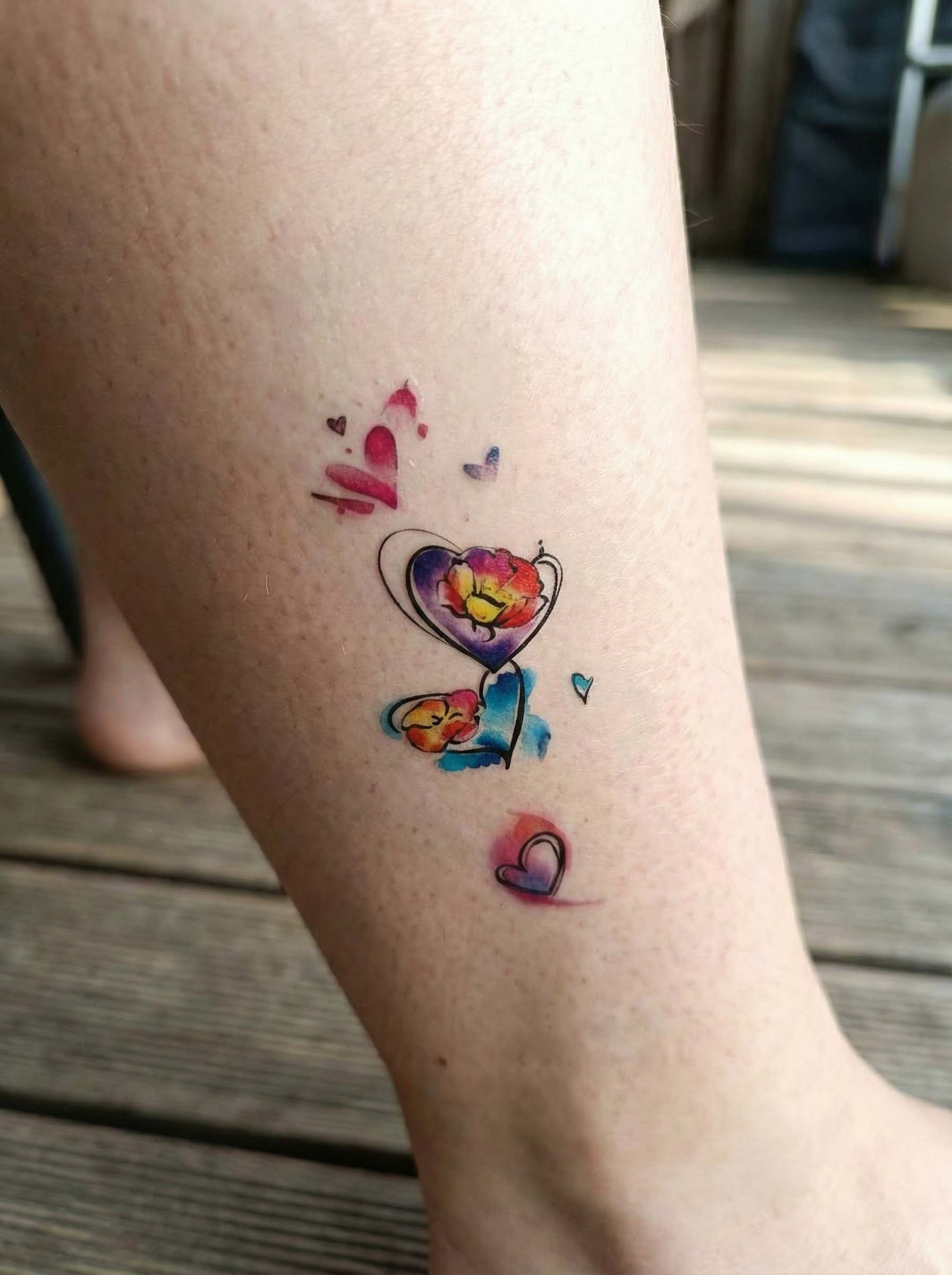Matte watercolor heart temporary tattoo on leg, colorful artistic semi-permanent tattoo design with a soft hand-drawn look