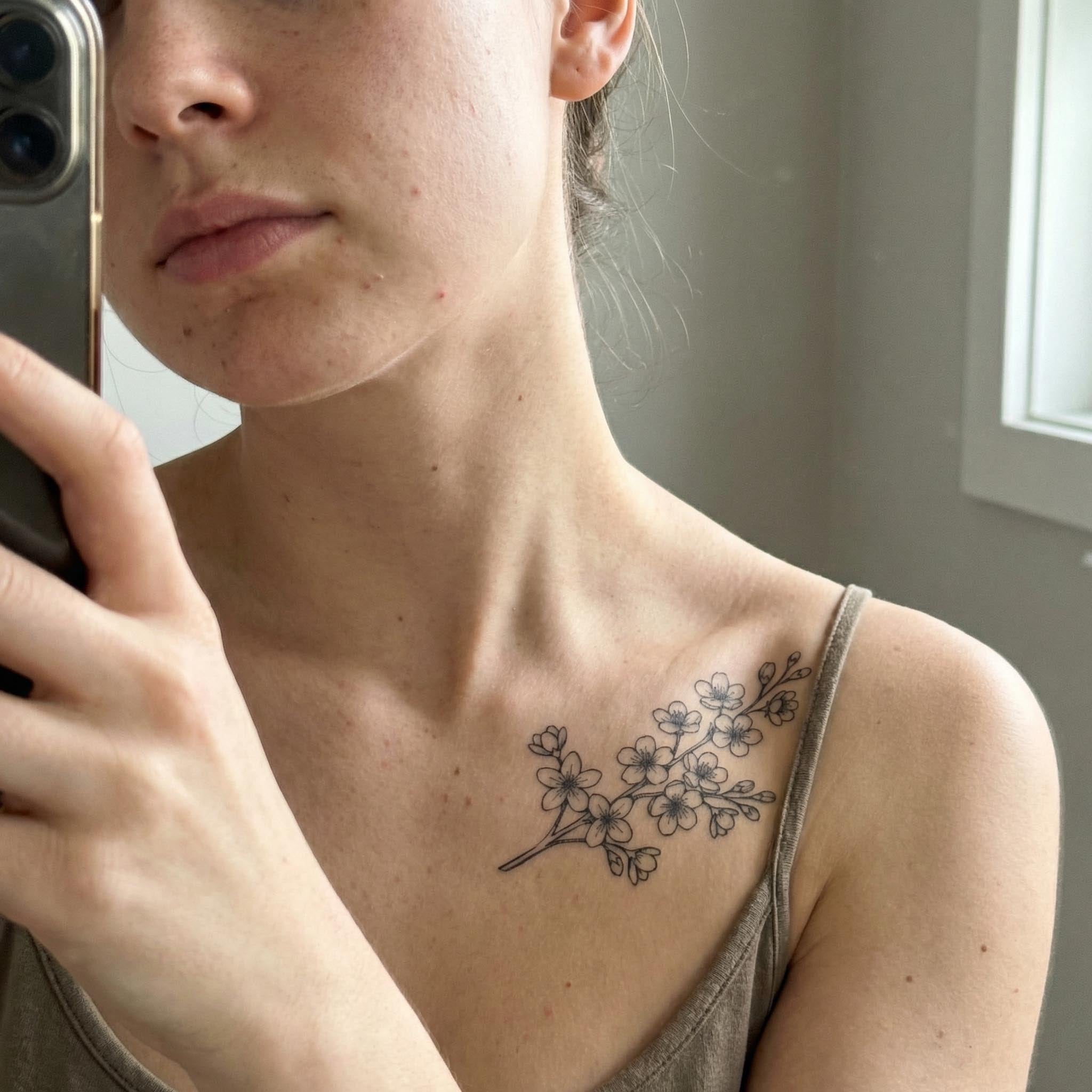 Cherry blossom floral fake tattoo worn on clavicle with delicate sakura details