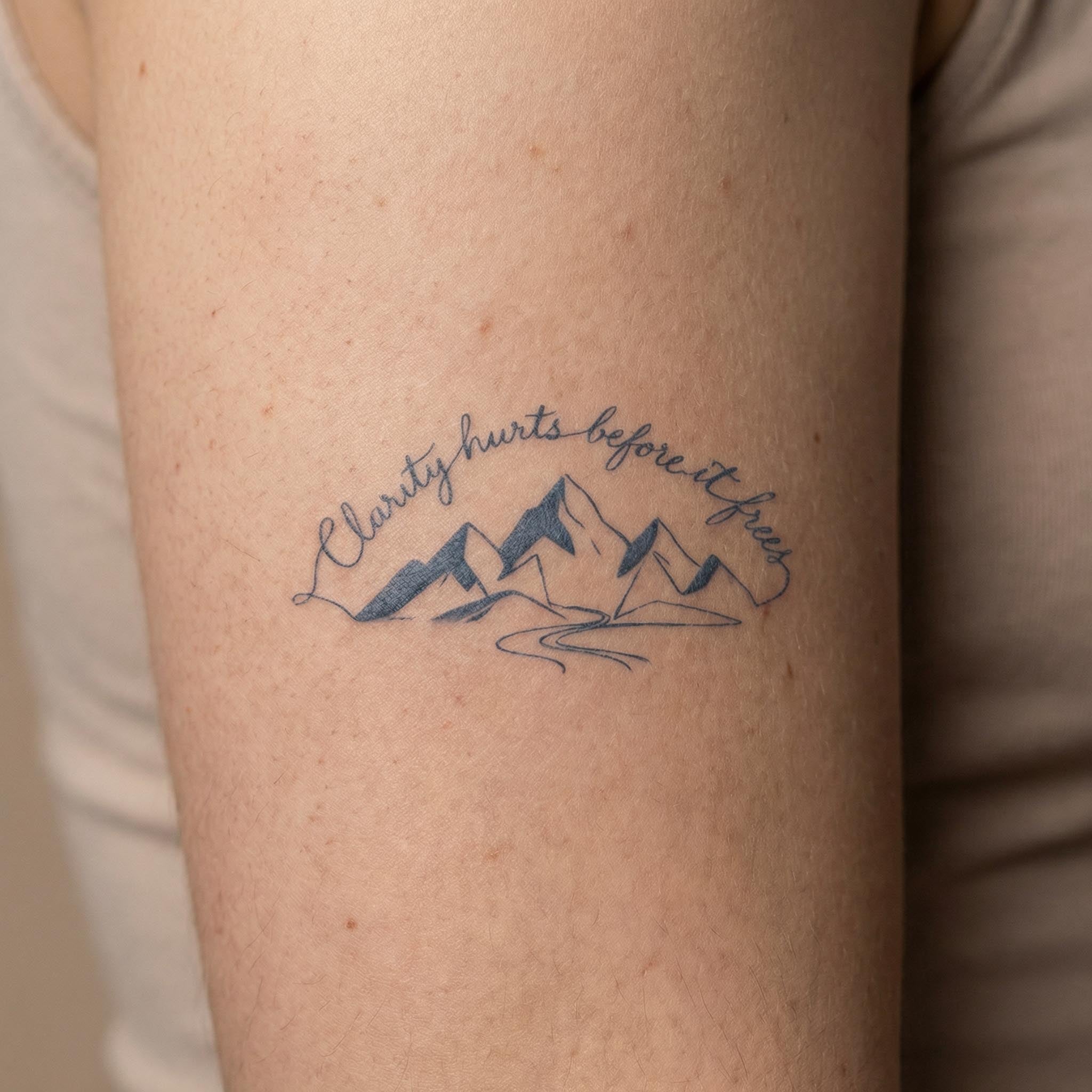 Minimal mountain temp tattoo worn on the forearm
