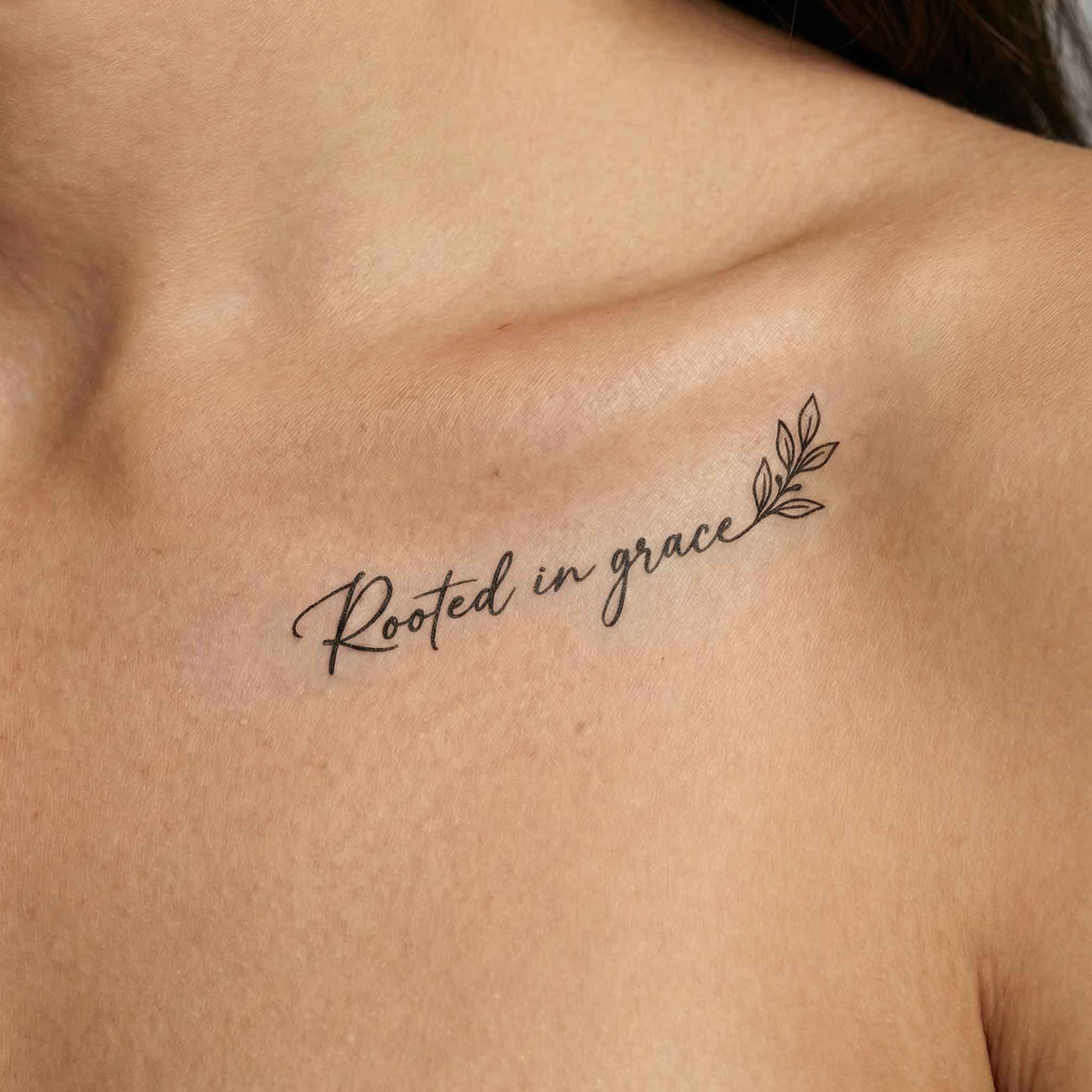Minimal script leaf tattoo worn on clavicle with delicate line detail